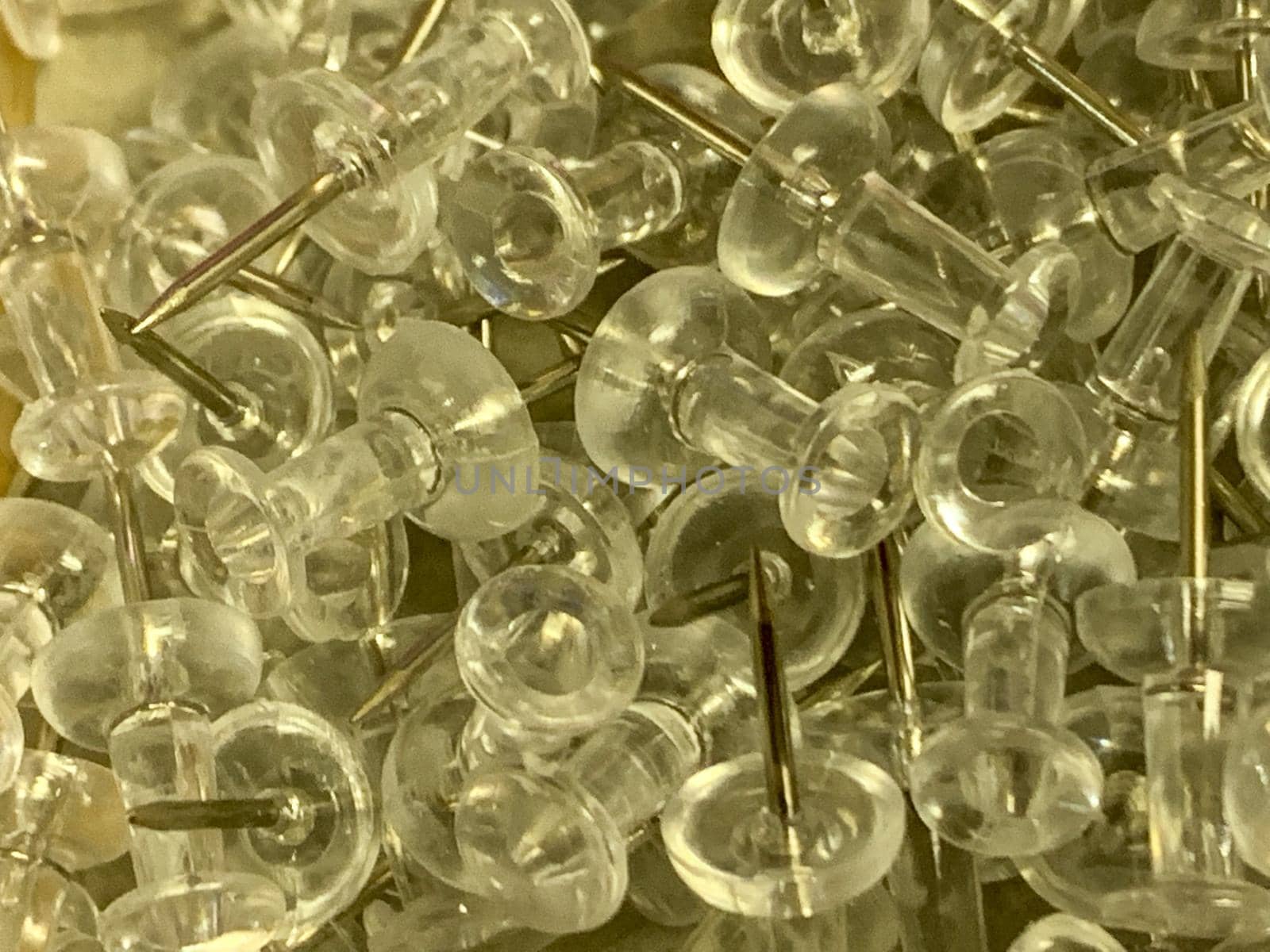 Push Pins in a pile on wooden desk close up by gena_wells