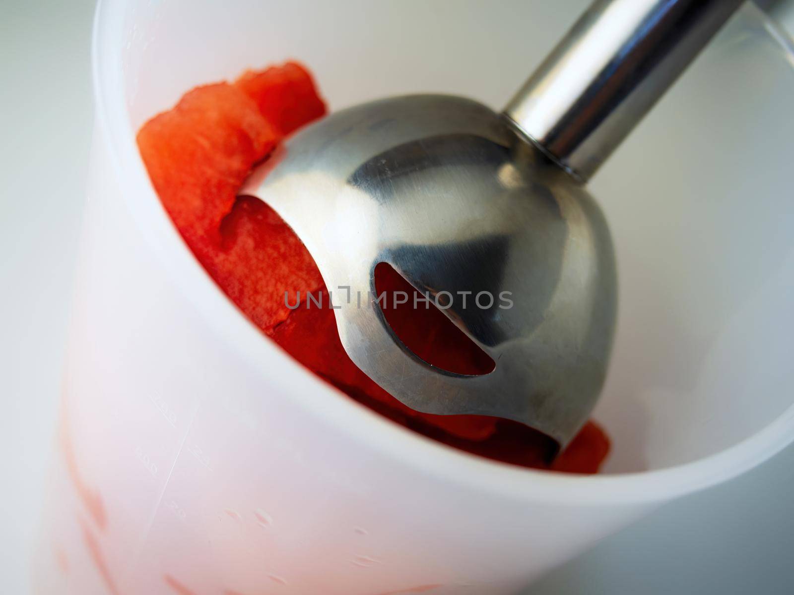 Roads of fresh watermelon in a bowl with a blender. Cooking fresh delicious watermelon smoothie.