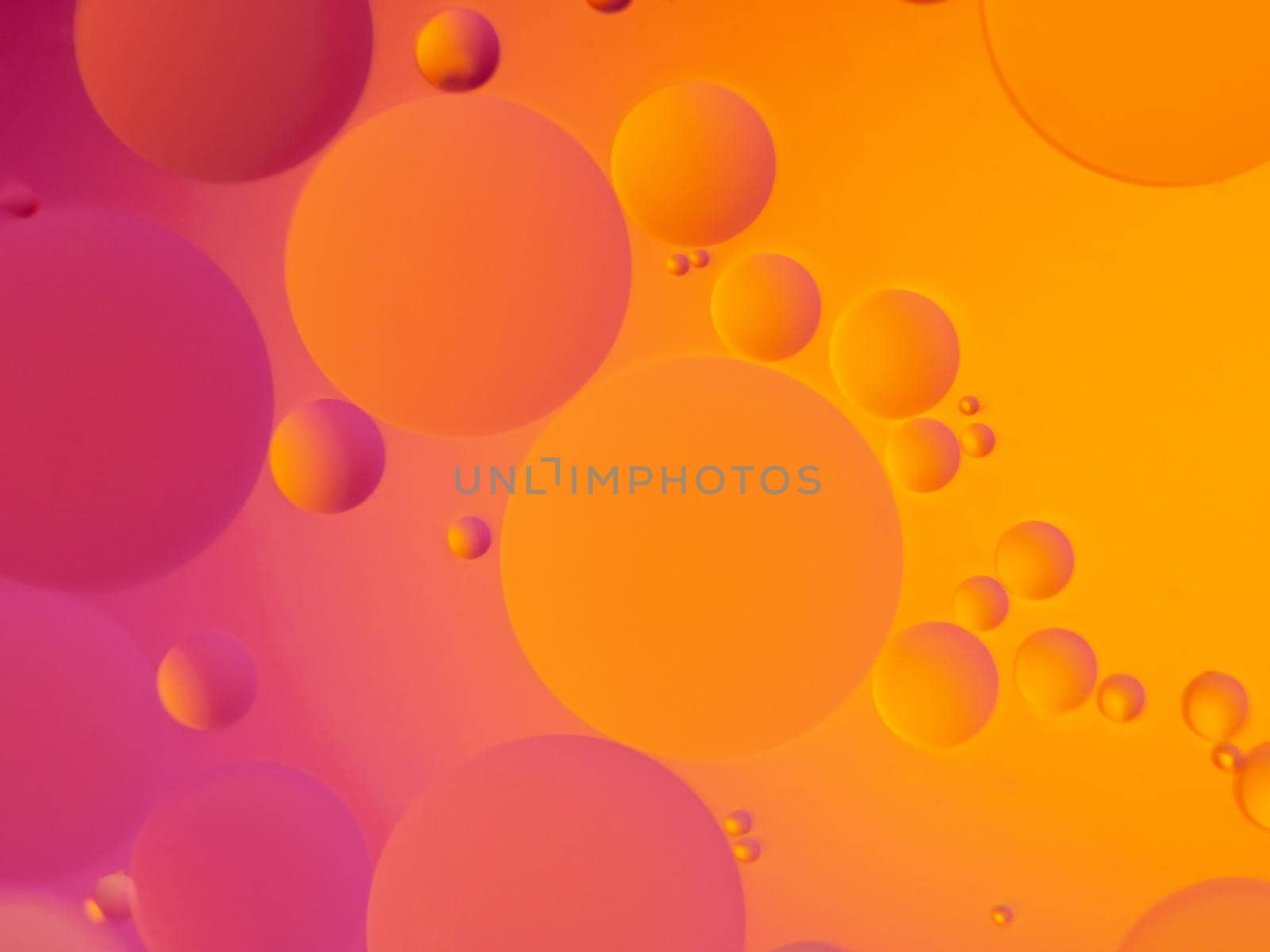 Abstract oil spots in motion on water on blurred yellow background. Photo with small depth of field.