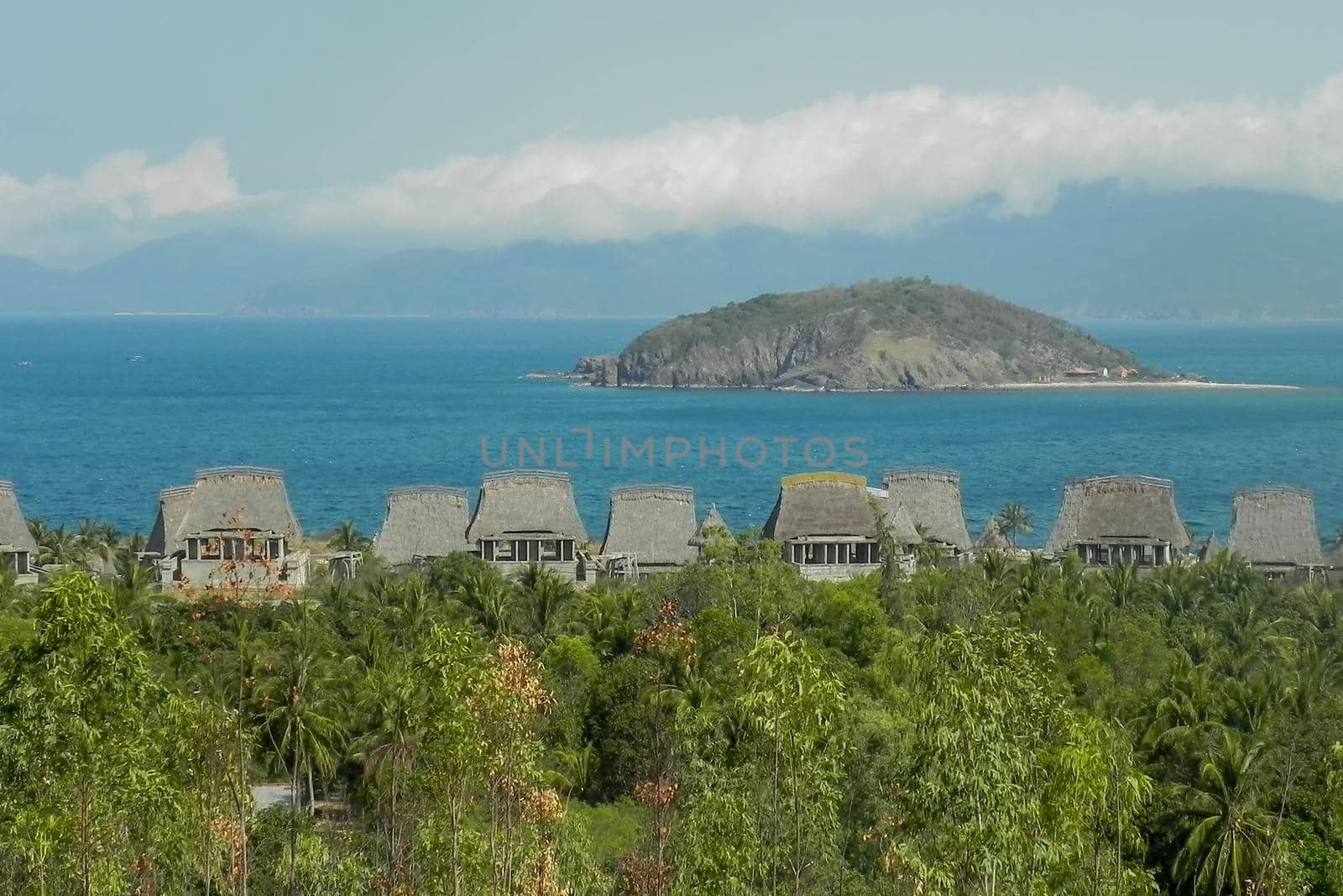 thatched-roof bungalows in the jungas against the backdrop of the sea and mountains