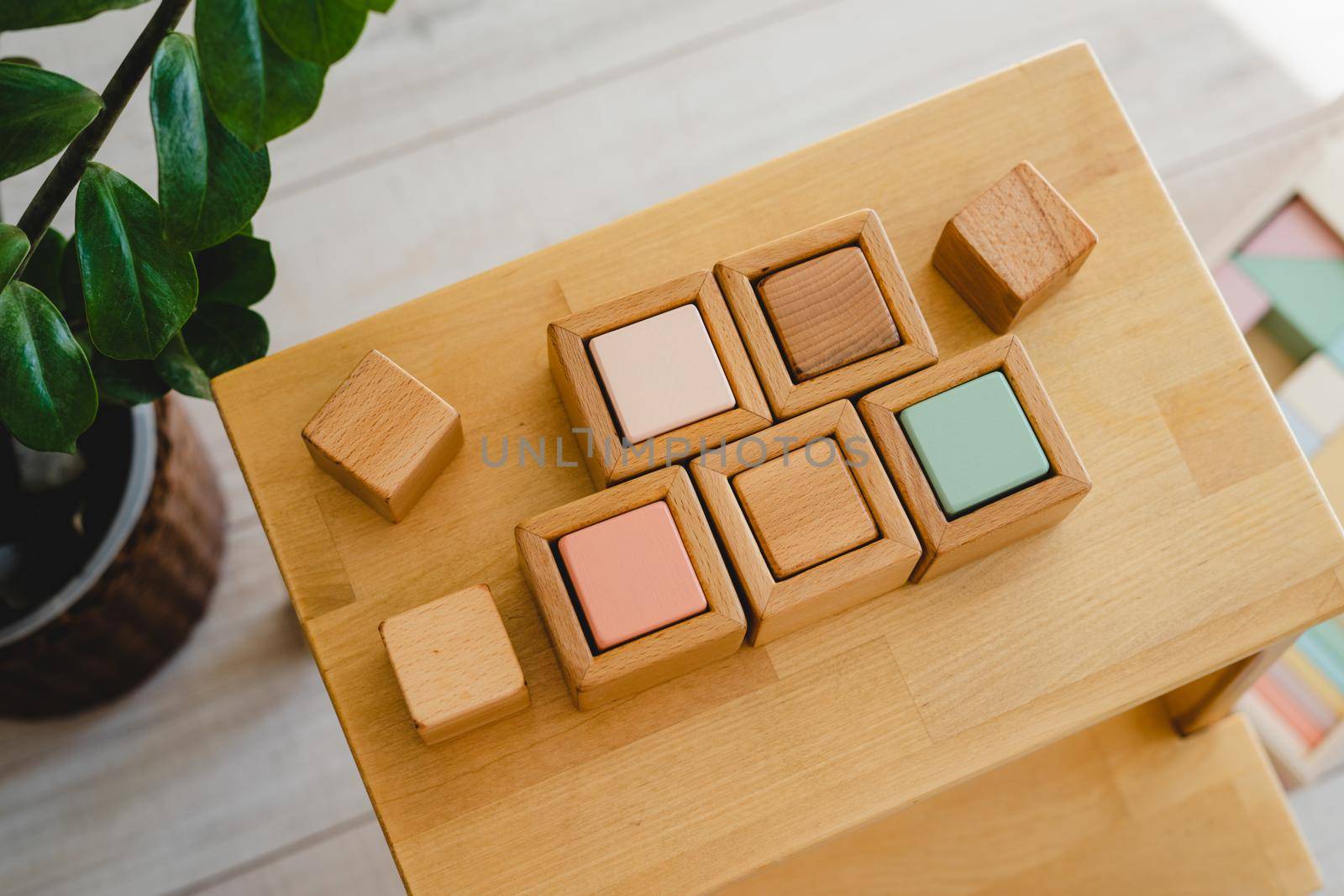 Wooden Montessori cubes. Eco-friendly toys for preschoolers. Toys made of natural material. No plastic toys. Wooden shelf with children's cubes.