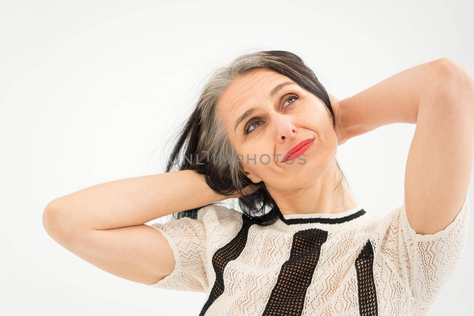 Studio photo of middle aged woman starting getting grey-haired wearing black and white clothes on white background, middle age sexy lady, happy life concept by balinska_lv