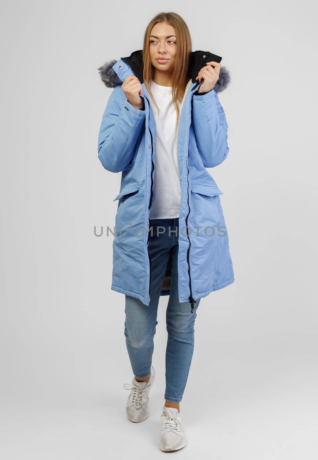 young woman in winter clothes on white background. Photo concept for advertising a down jacket by UcheaD