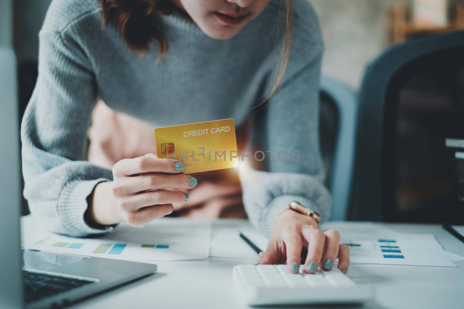 Woman calculating amount credit card and house bill of this month at home. online payment, shopping, ecommerce concept.