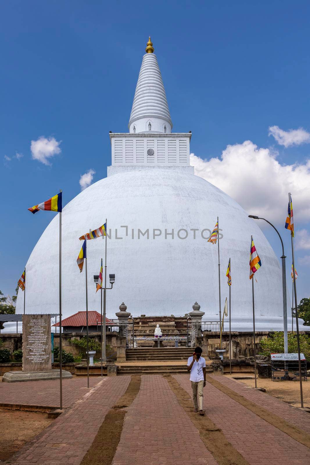 Sri Lanka. Anuradhapura. Mirisawetiya Vihara. The Mirisaveti Stupa (pagoda). Popular attraction. Front view - the road to the landmark with flags. High quality photo