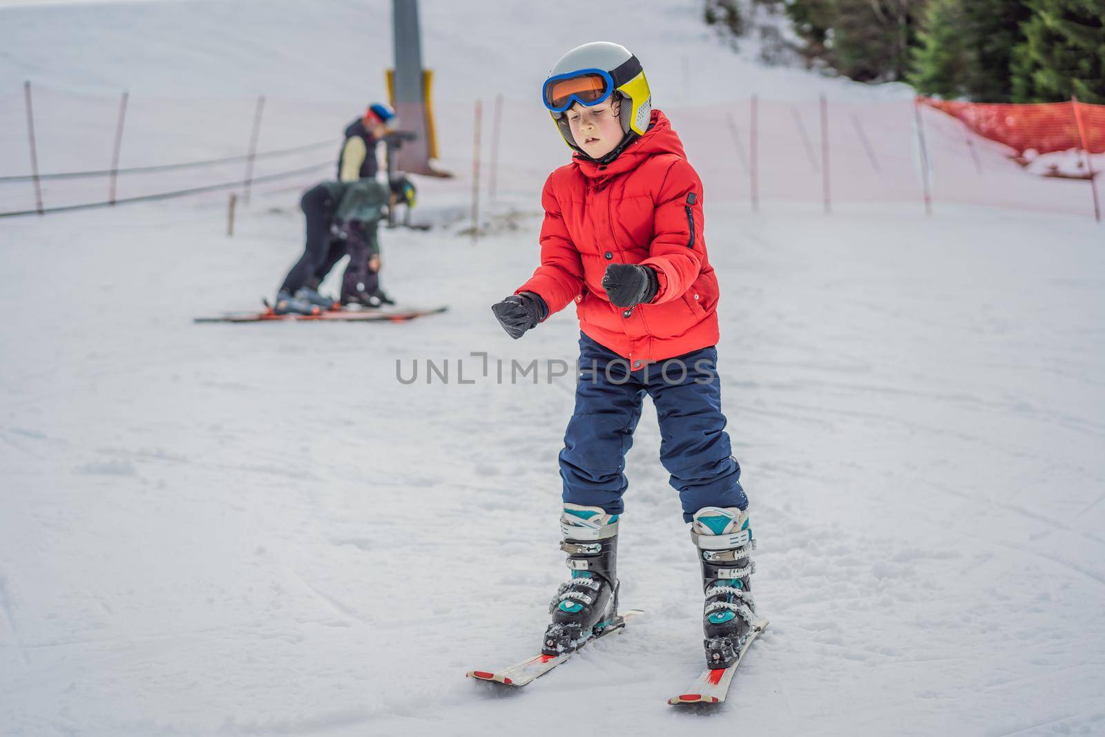 Child skiing in mountains. Active toddler kid with safety helmet, goggles and poles. Ski race for young children. Winter sport for family. Kids ski lesson in alpine school. Little skier racing in snow.