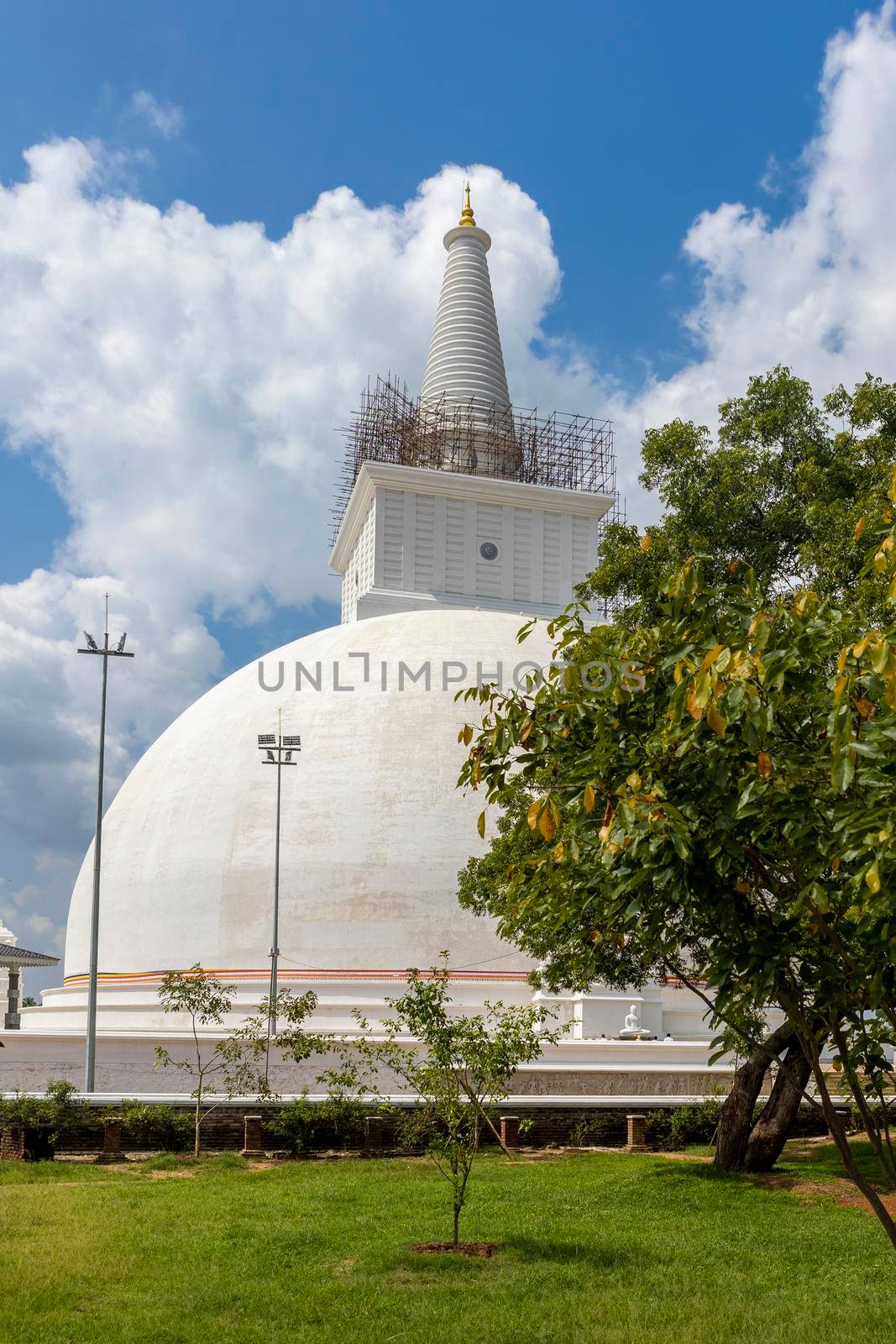 The Ruwanweli Maha Seya, also known as the Mahathupa (the Great Thupa) is a stupa in Anuradhapura, Sri Lanka. Popular attraction. View from garden with beautiful trees. High quality photo