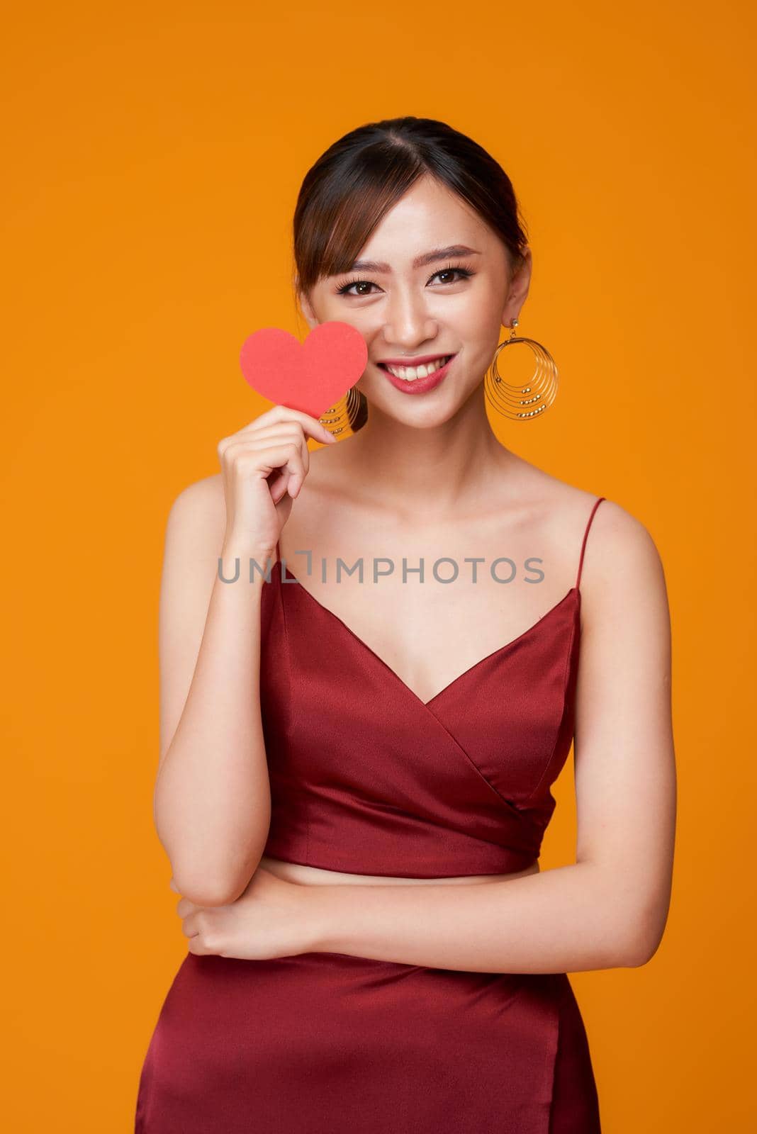 Woman holding paper heart shaped card  by makidotvn