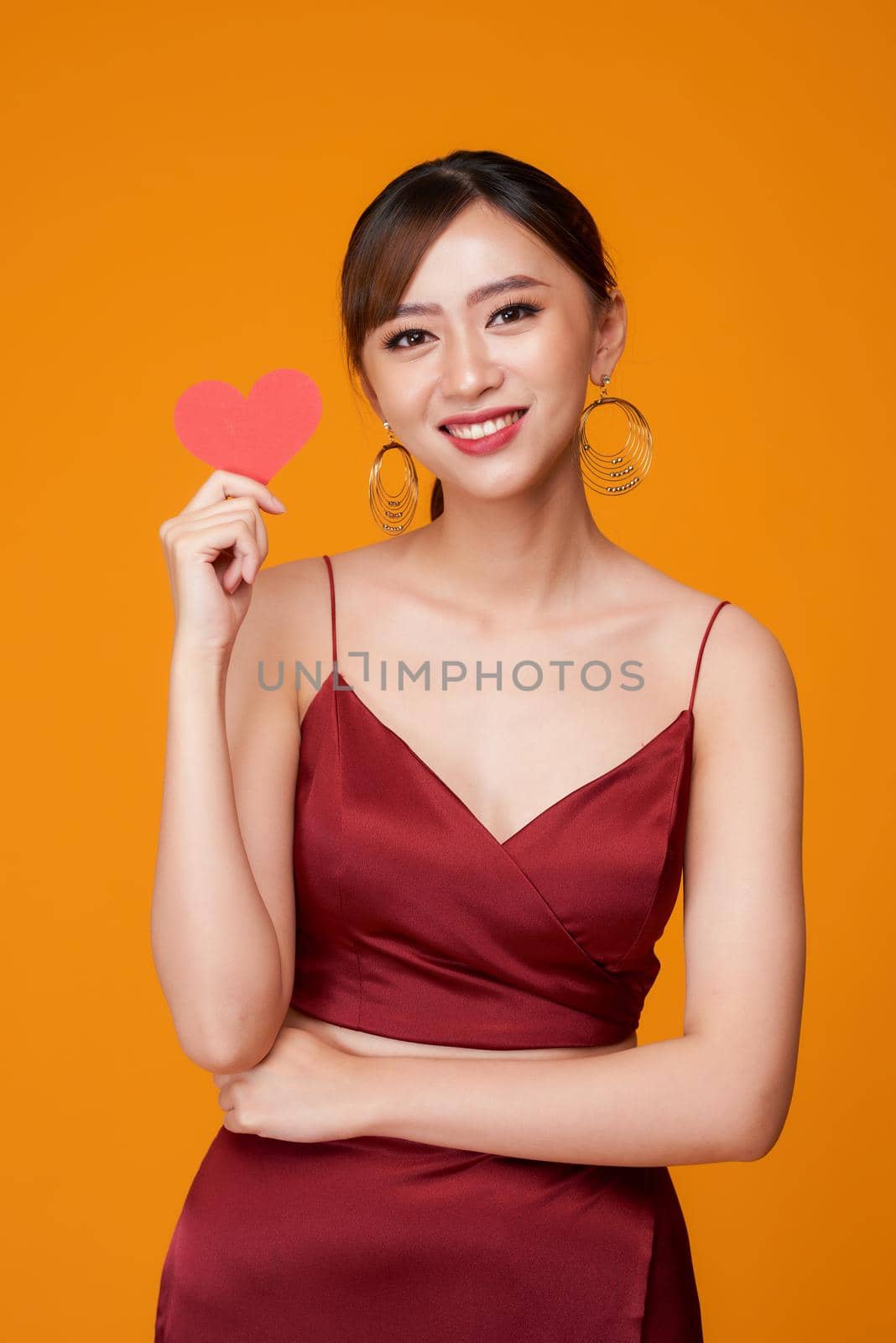 Woman holding paper heart shaped card  by makidotvn