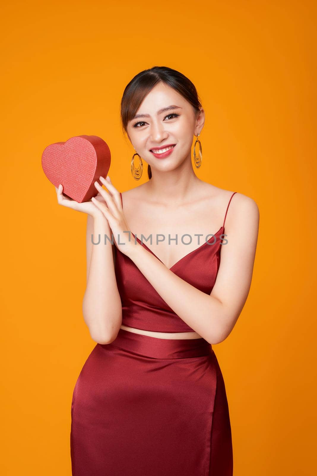 Beautiful woman with heart shaped box on color background. by makidotvn