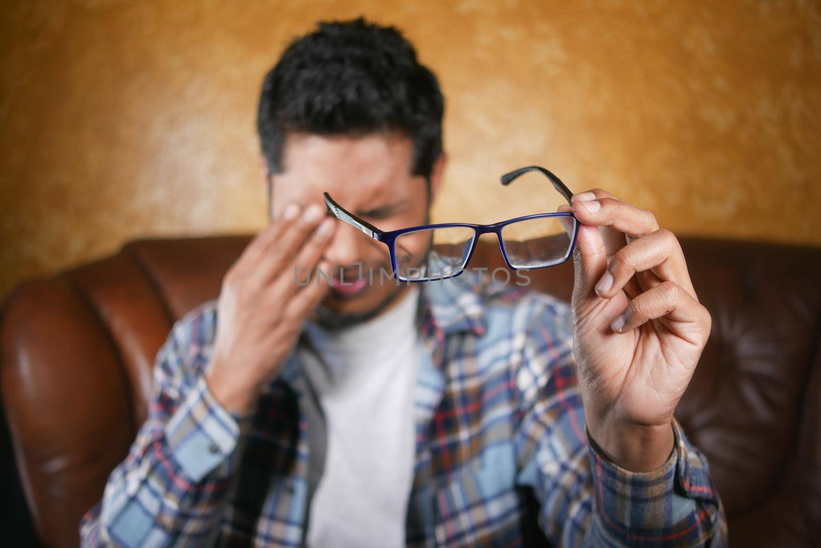 Close up of upset man suffering from strong eye pain.