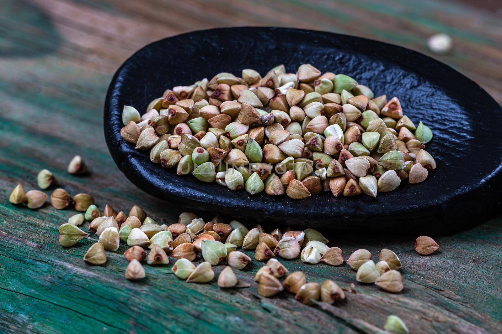 Sarasin seeds in macro in a wooden spoon on a green background