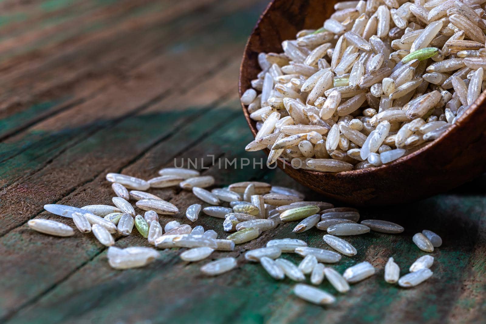 Rice grains in macro in a wooden spoon.