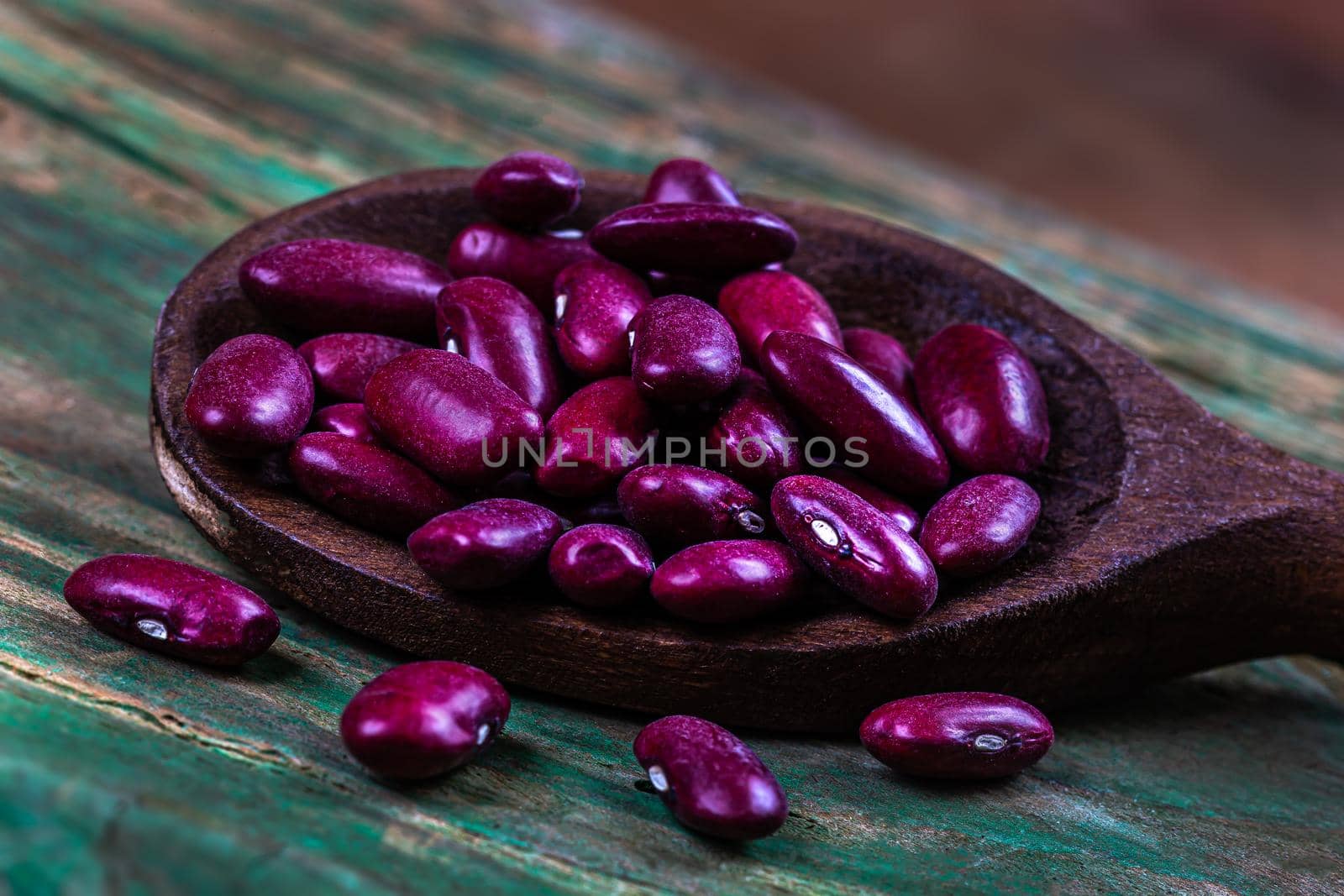 Red beans in close-up in a wooden spoon