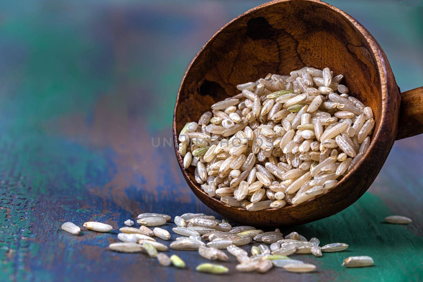 Rice grains in macro in a wooden spoon.