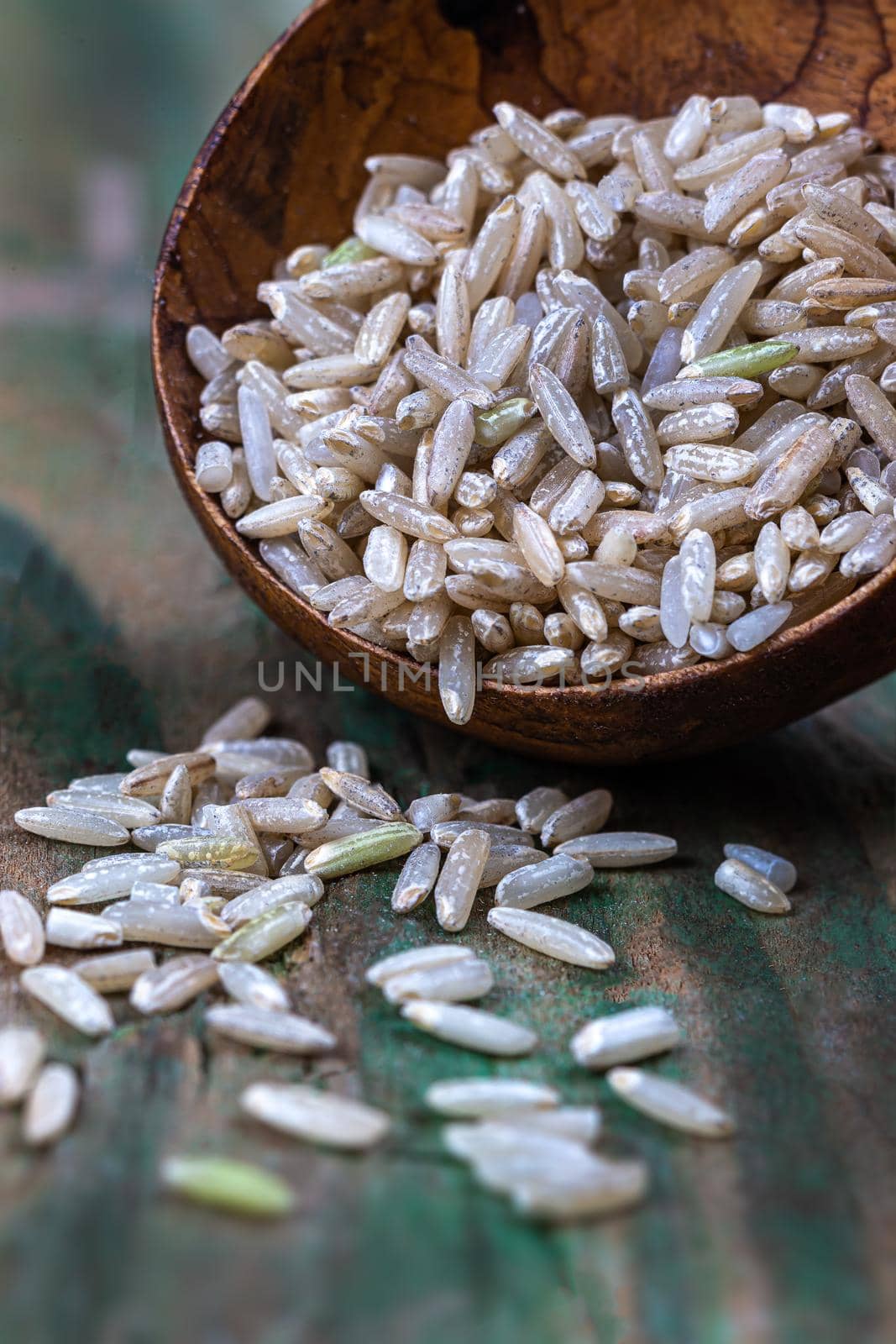 Rice grains in macro in a wooden spoon.