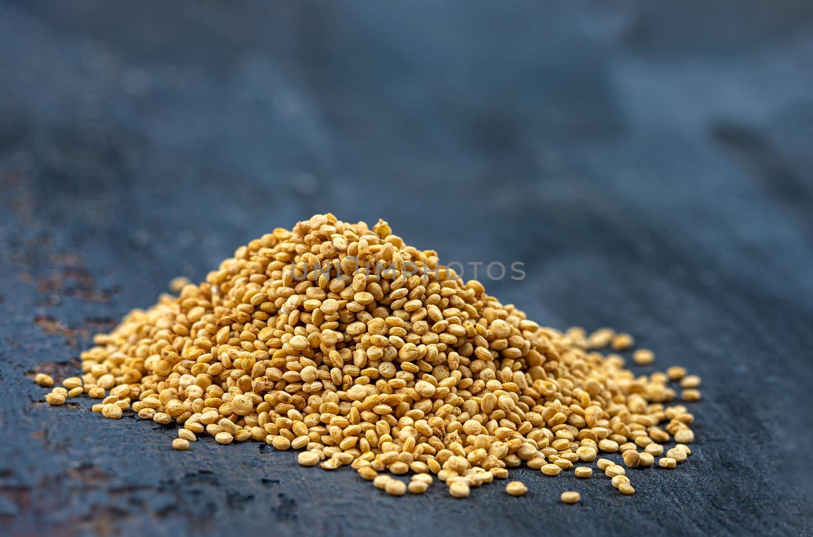 Heaps of Quinoa grains in close-up on a dark background