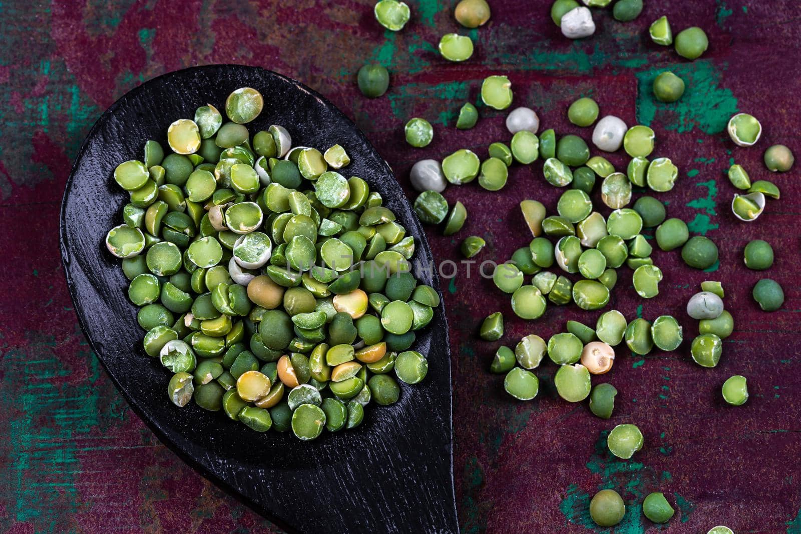 Peas scattered on a foce bottom on wooden spoon