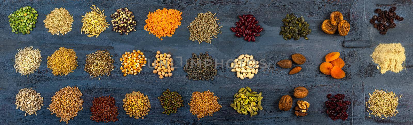 Panoramic of a wide range of cereals, dried fruits hard background gray foc