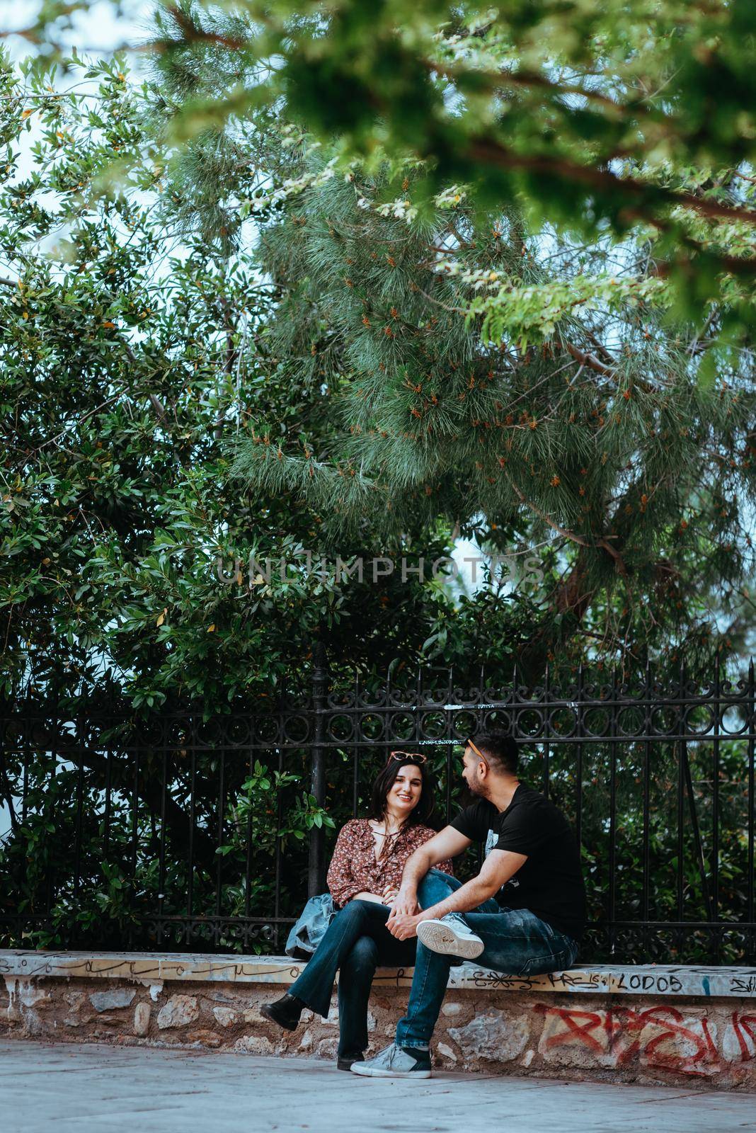 Athens, Greece, May 21, 2019: Park outdoor, young, loving couples relaxing on benches, editorial by Andrii_Ko