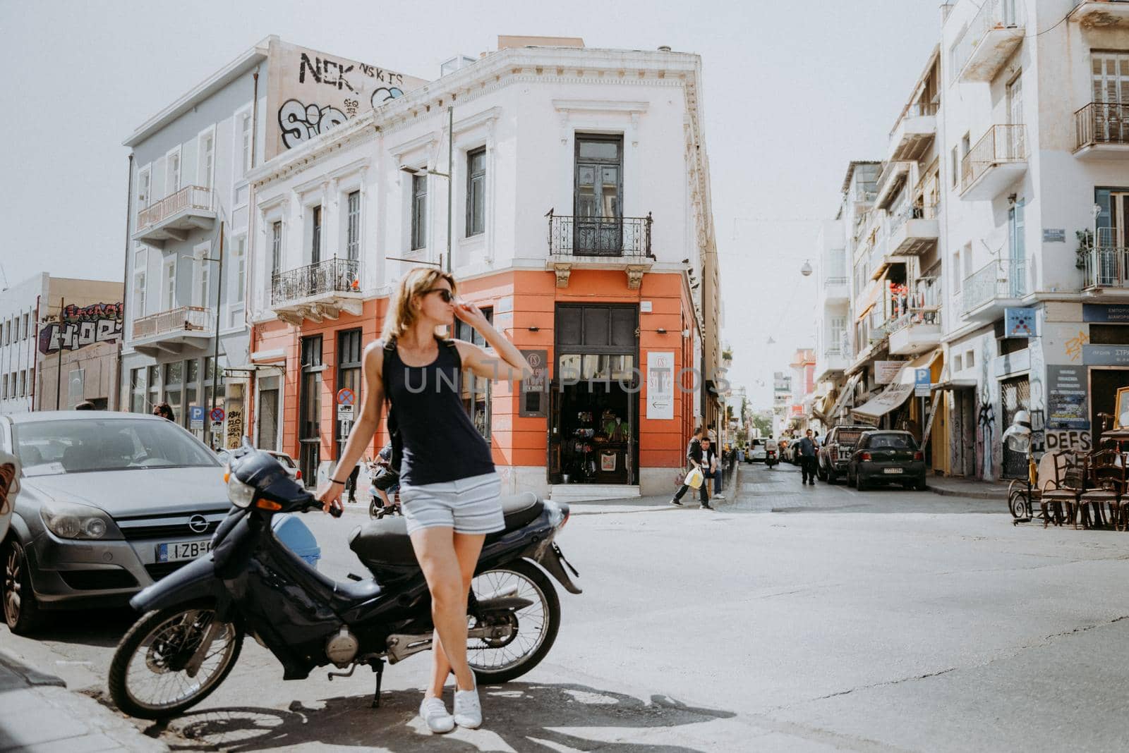 Beautiful girl walking along the street of an old European town, capital of Greece - Athens. Portrait of a tourist girl walking on the street background. by Andrii_Ko