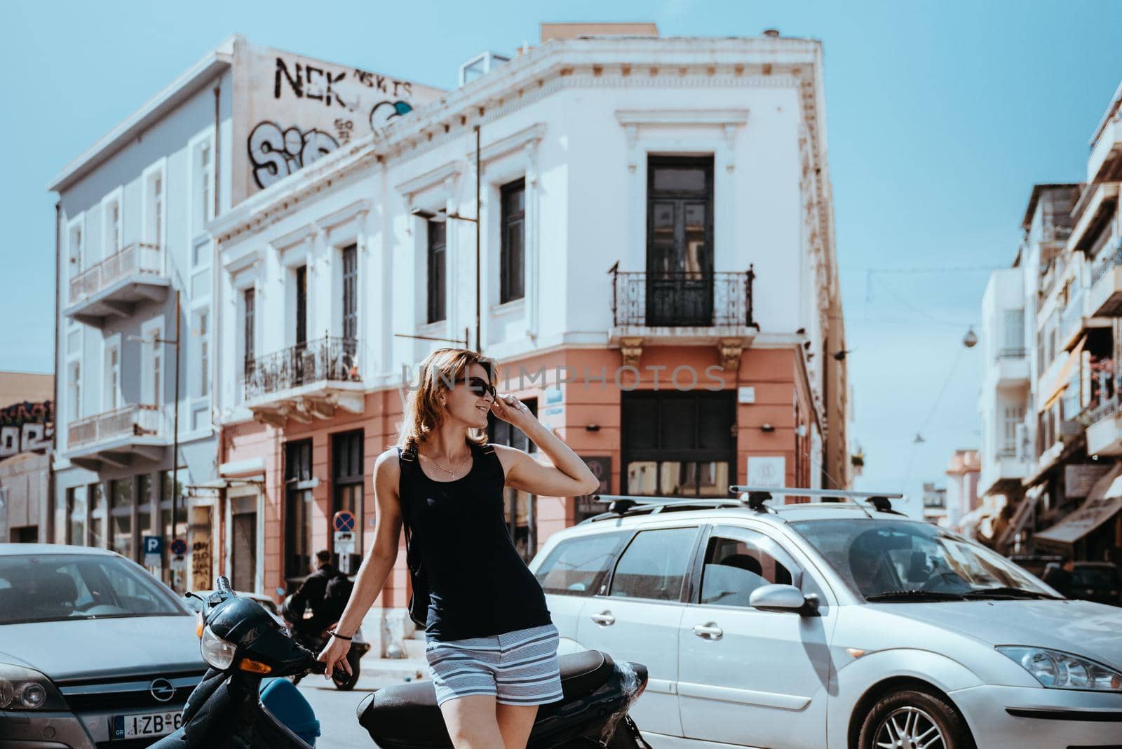 Beautiful girl walking along the street of an old European town, capital of Greece - Athens. Portrait of a tourist girl walking on the street background. by Andrii_Ko