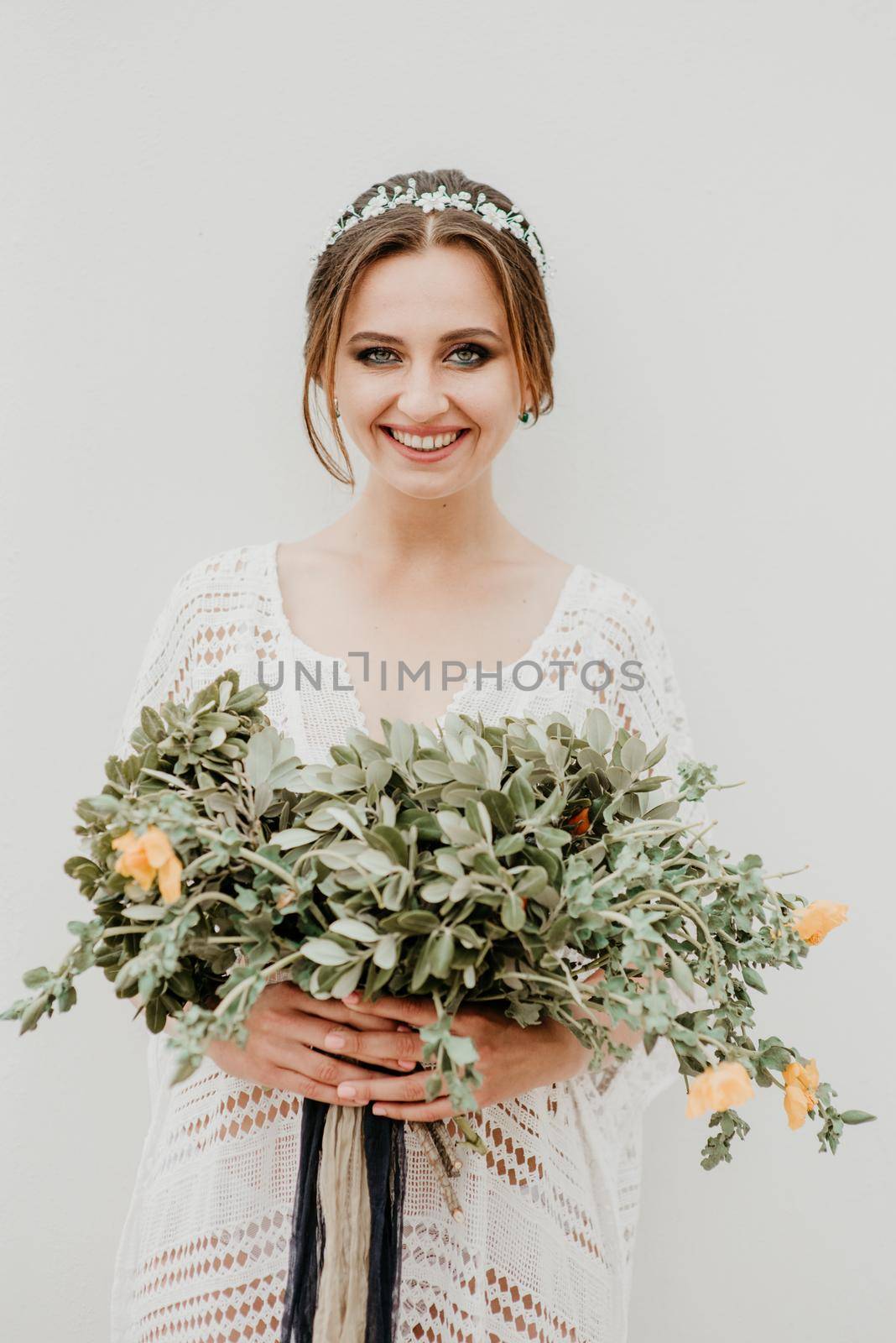 Young attractive bride with the bouquet of flowers.