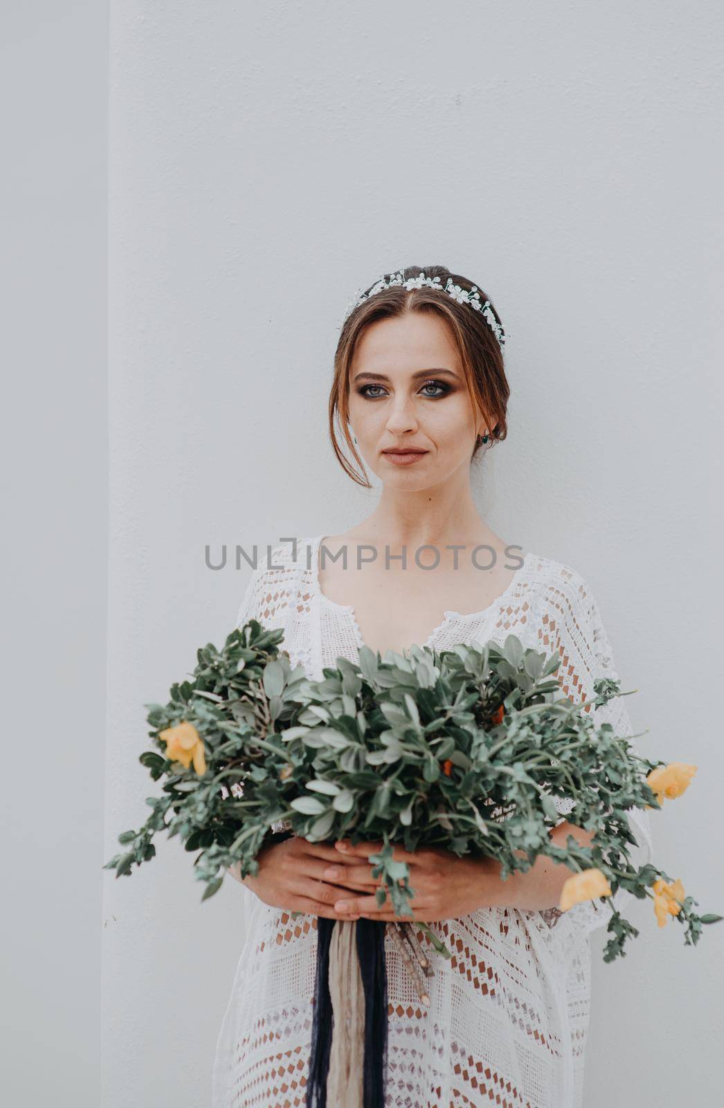 Young attractive bride with the bouquet of flowers.