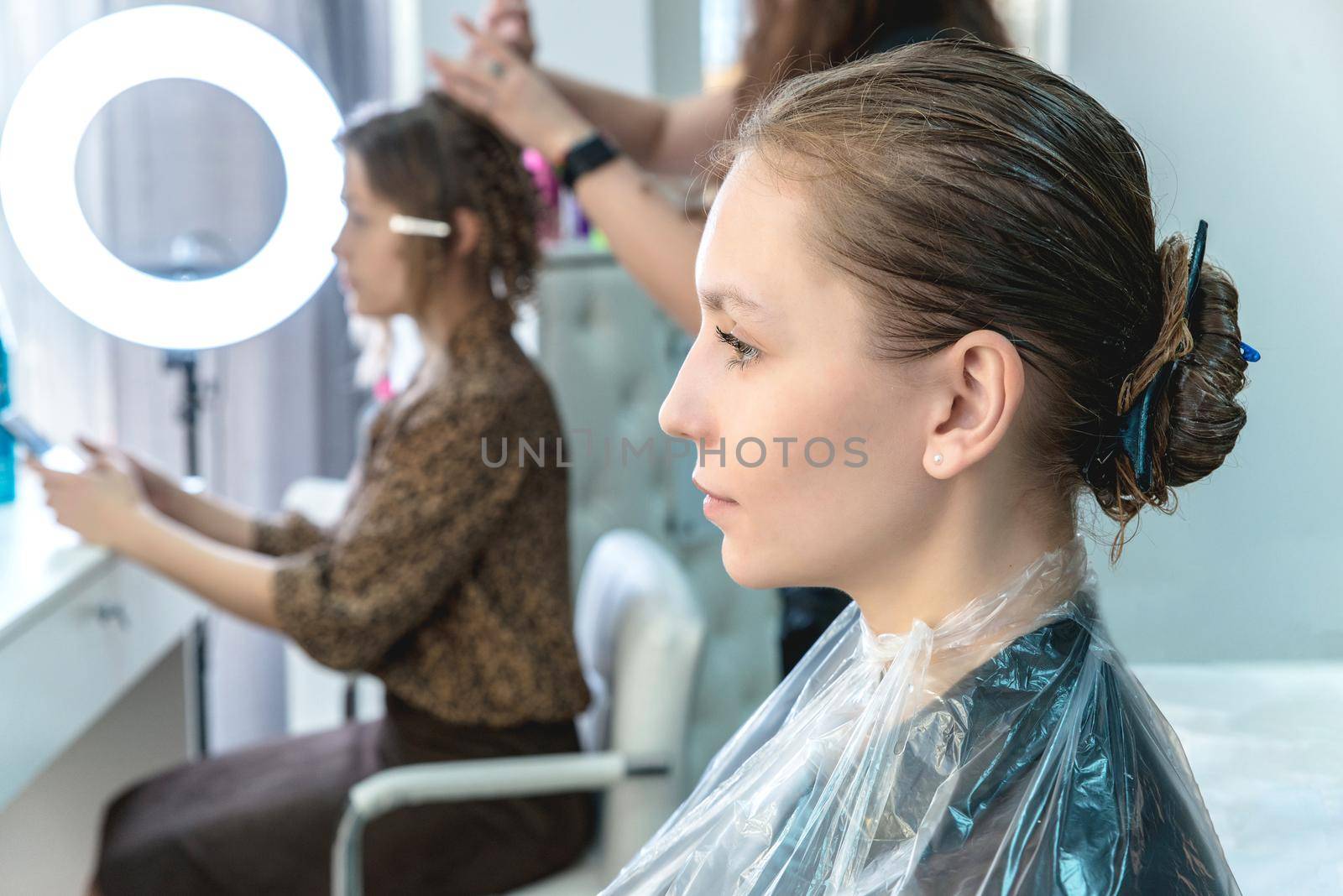 hair coloring in a beauty salon, young girl during dyeing process by Mariakray