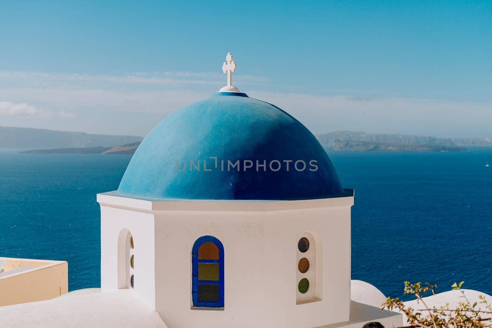 Blue domed church in Oia overlooks the spectacular caldera surrounding the beautiful island of Santorini, Greece by Andrii_Ko