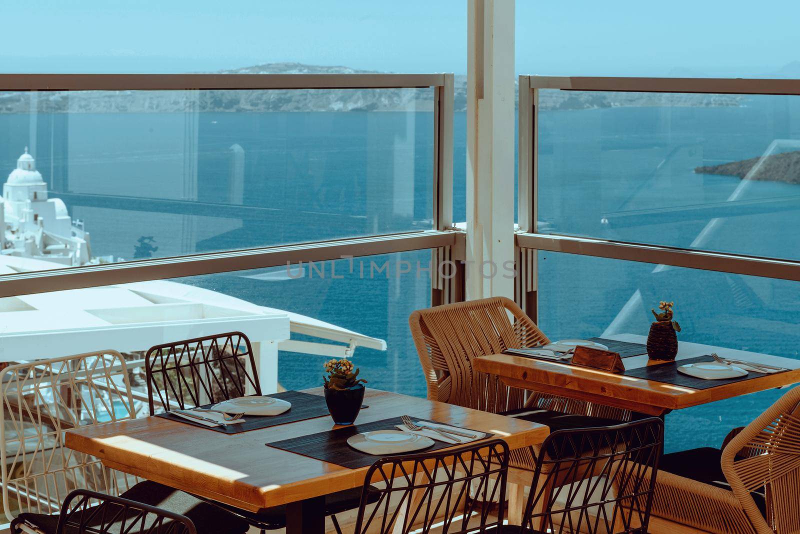 Dinning tables in a restaurant on Santorini island, Greece by Andrii_Ko