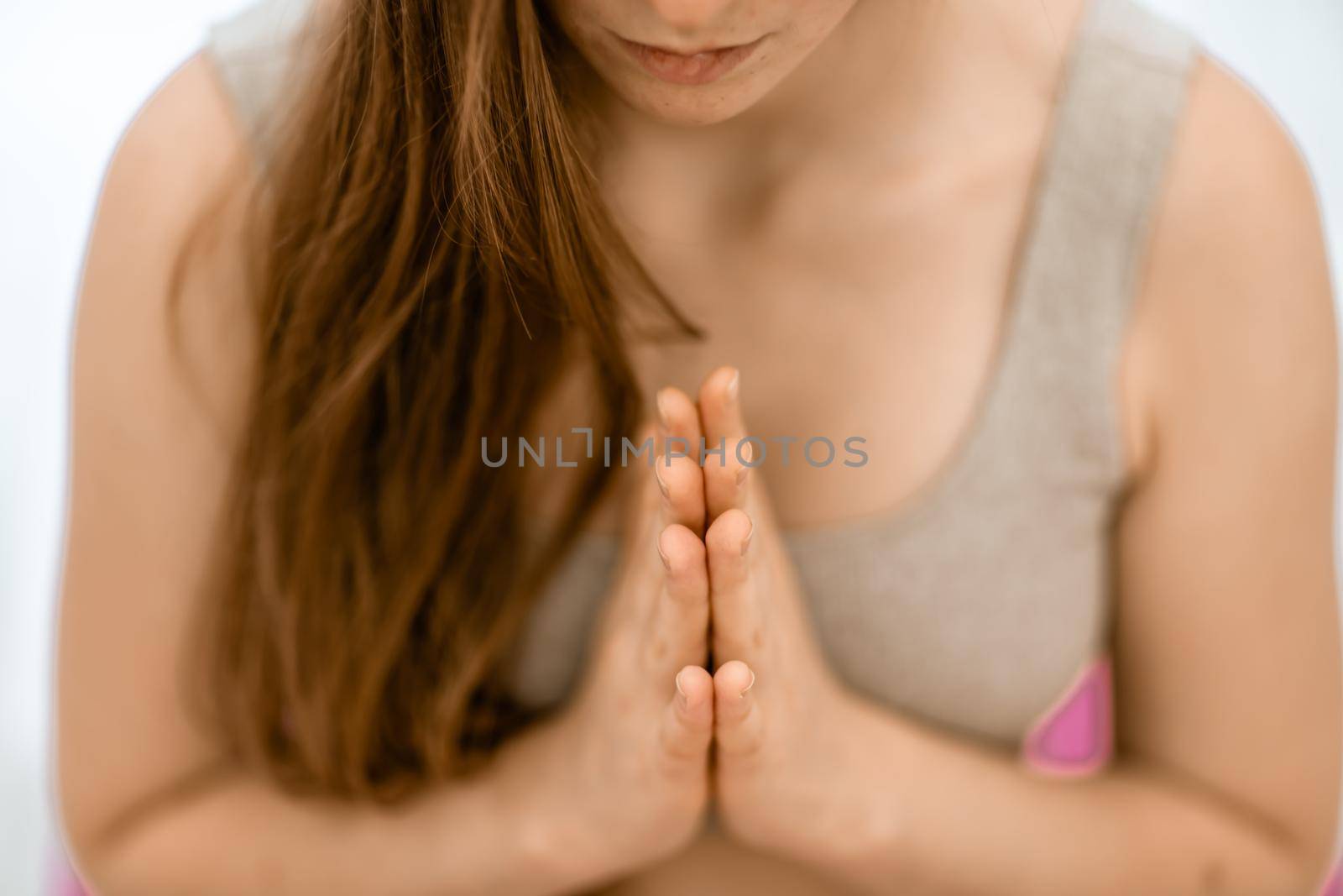 Girl does yoga. Young woman practices asanas on a beige one-ton background. by Matiunina