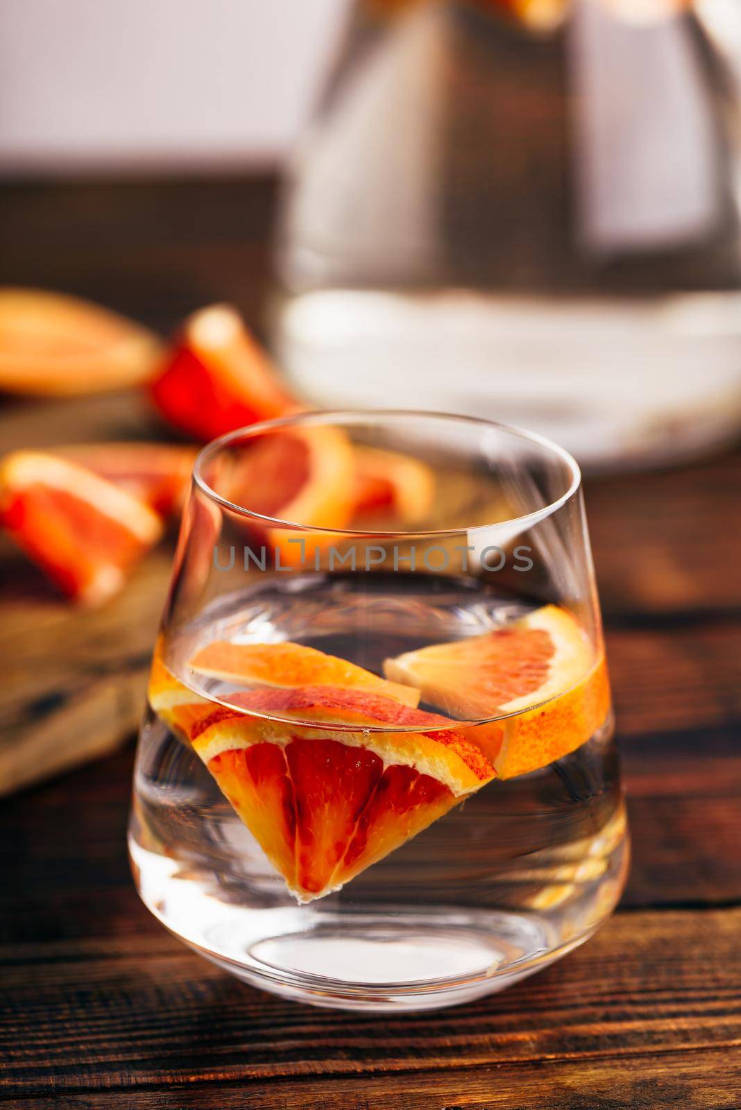 Infused water with bloody oranges in drinking glass