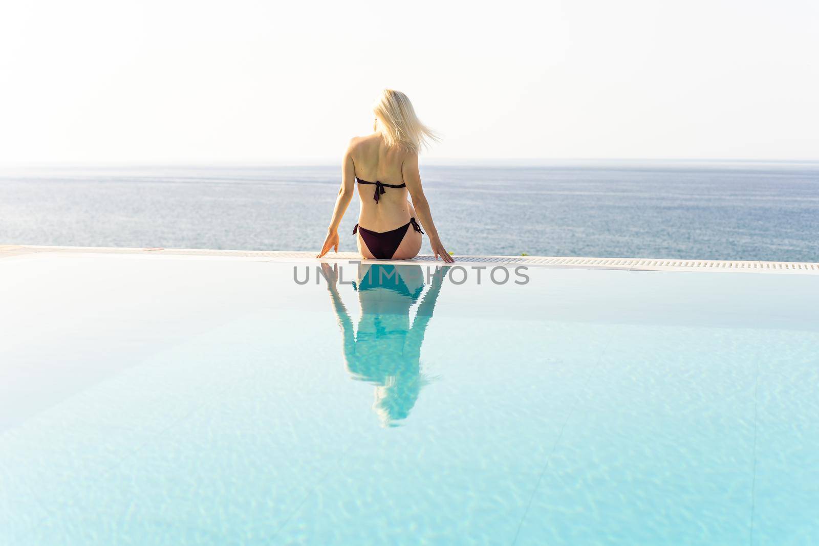 Young sexy blonde woman posing near the pool. Young pretty woman