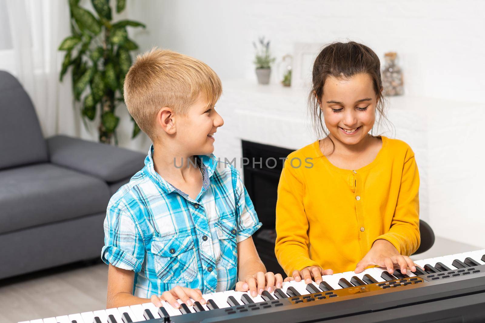 Brother and sister play the synthesizer. Children play at piano. family games.