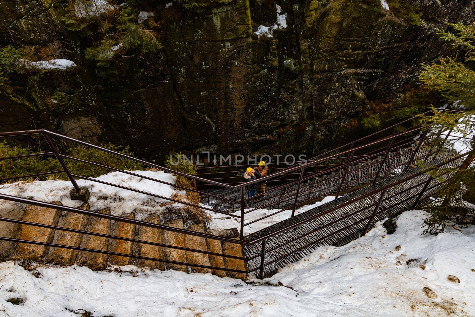 Two people standing downstairs on small steel footbridge