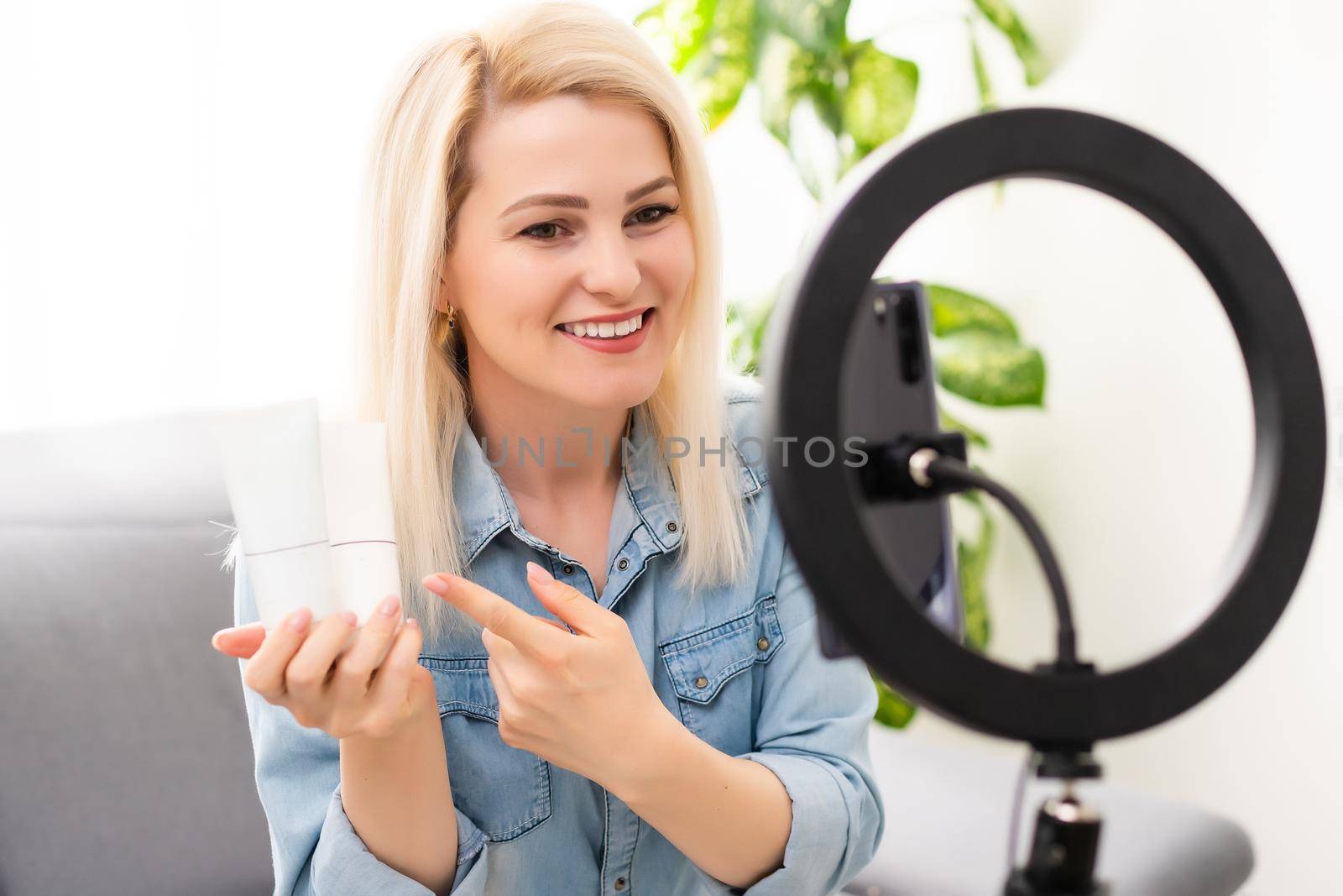 blogger woman records video with round lamp.