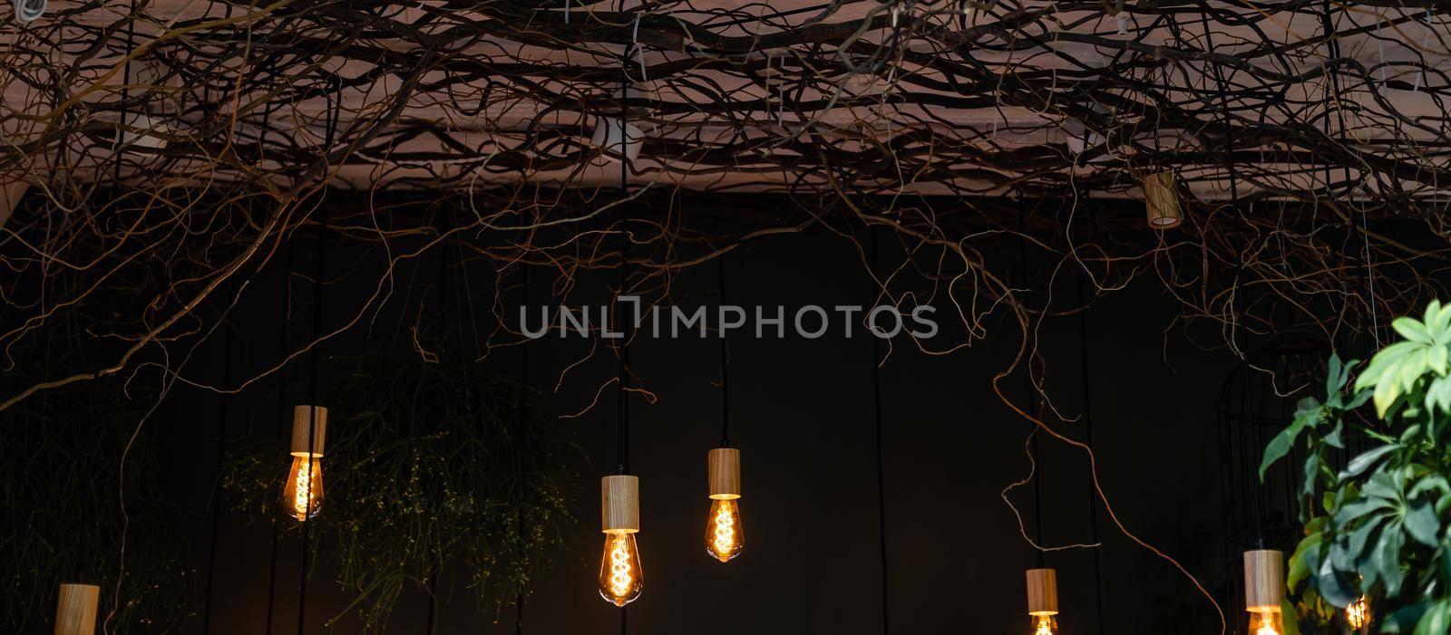 Light bulb with wooden minimal ceiling lamp design in warm green and wooden home background, with blank copy space