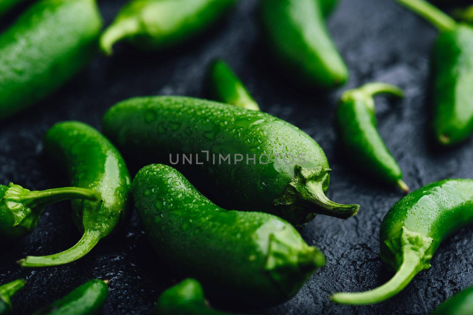 Green Jalapeno Peppers on Dark Concrete Background