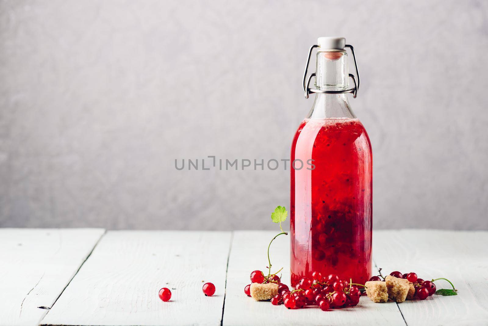 Bottle of infused water with fresh red currant and cane sugar