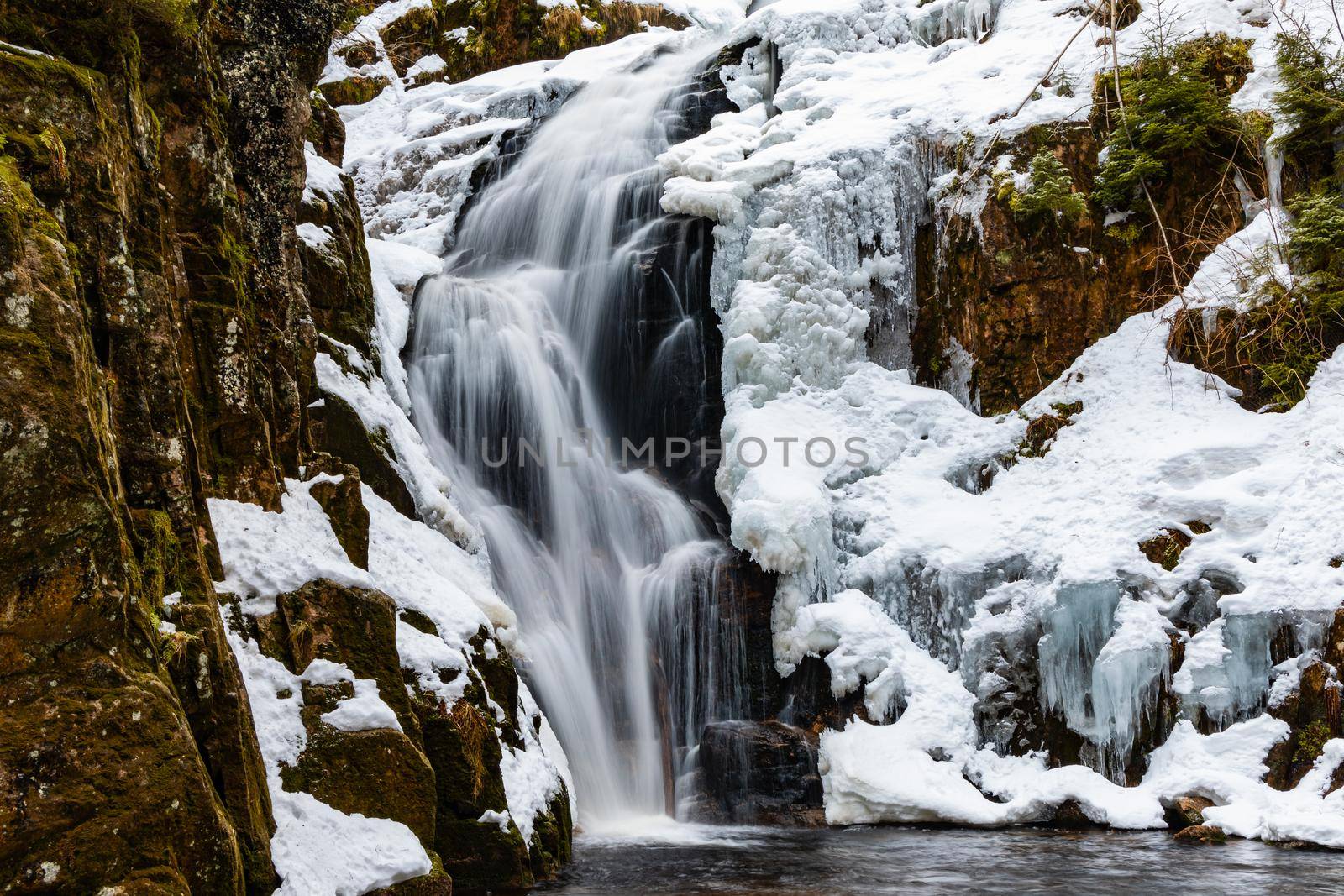 Long high waterfall in mountains full of snow and ice around by Wierzchu