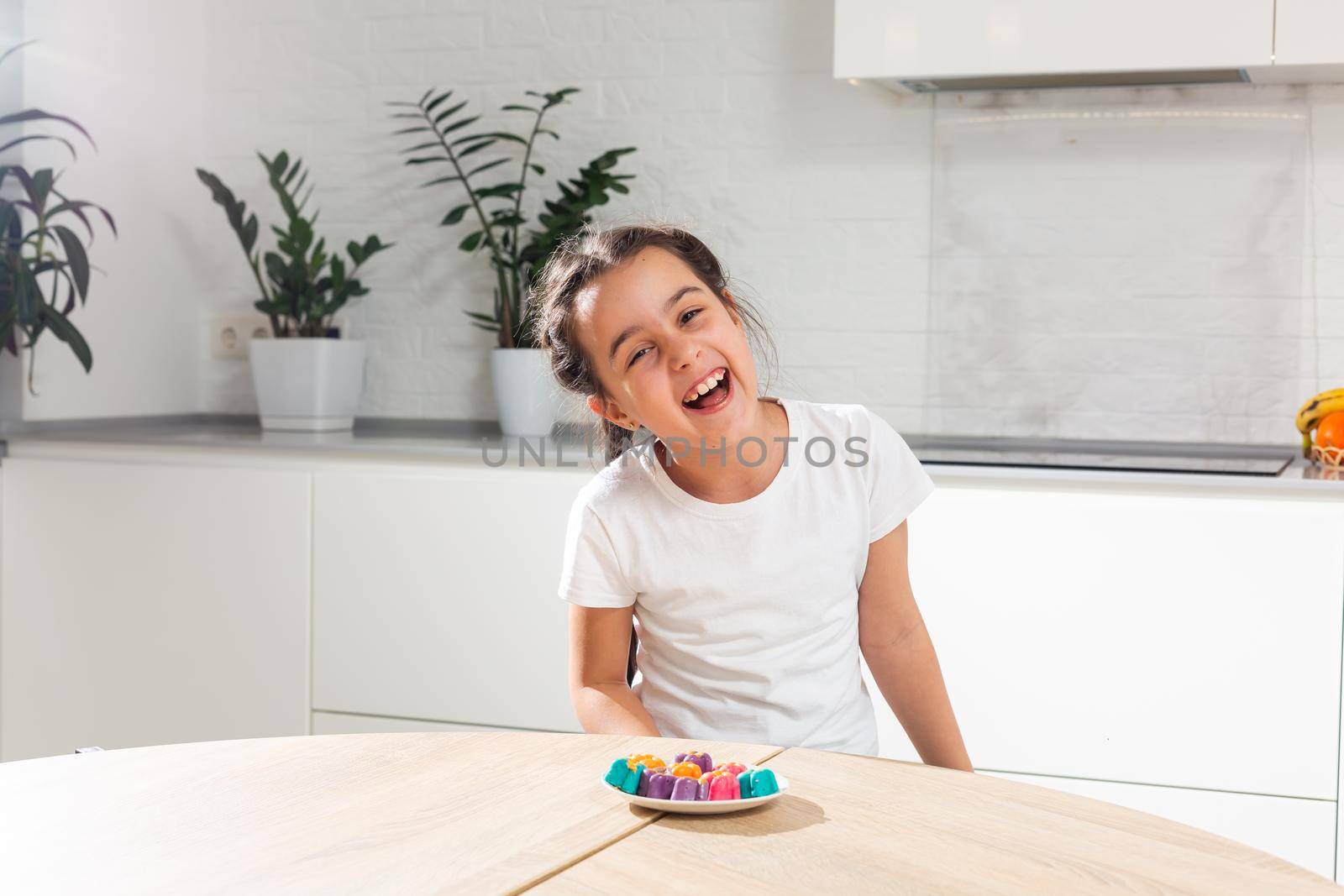 Small girl celebrating Holi Festival of Colors holding tray in hand.