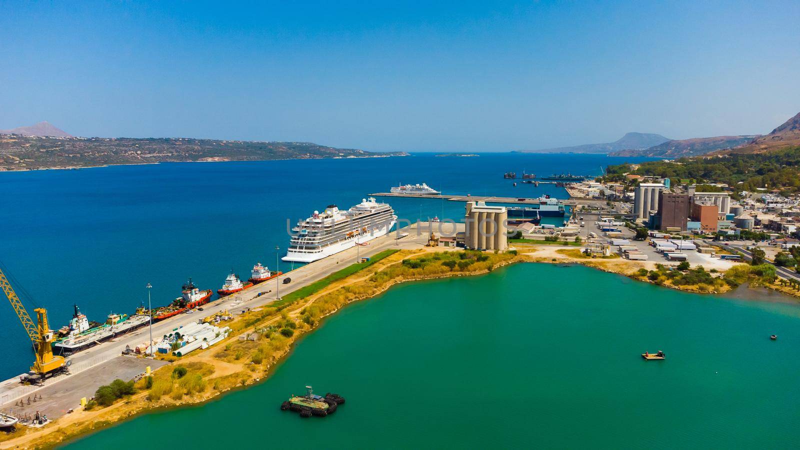 Crete, Greece. In the foreground - sea and pier of Heraklion port, loading equipment, cruise liners, yachts, in the background by Andelov13