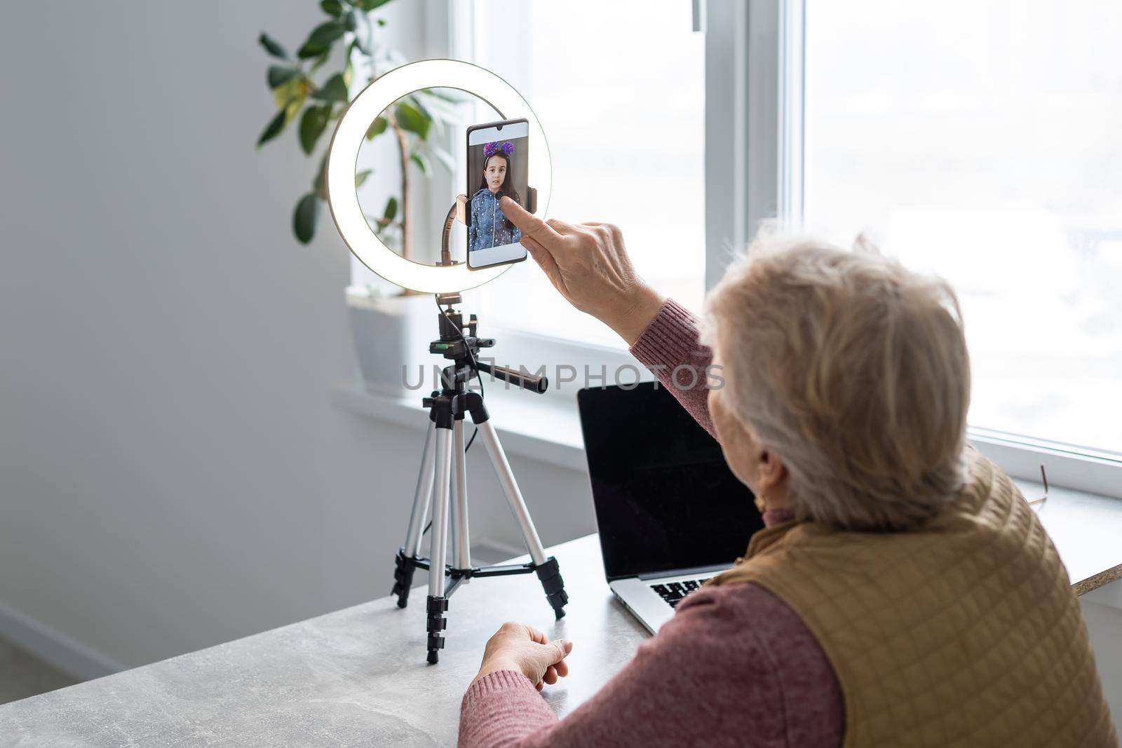 elderly woman writes a video for a blog.