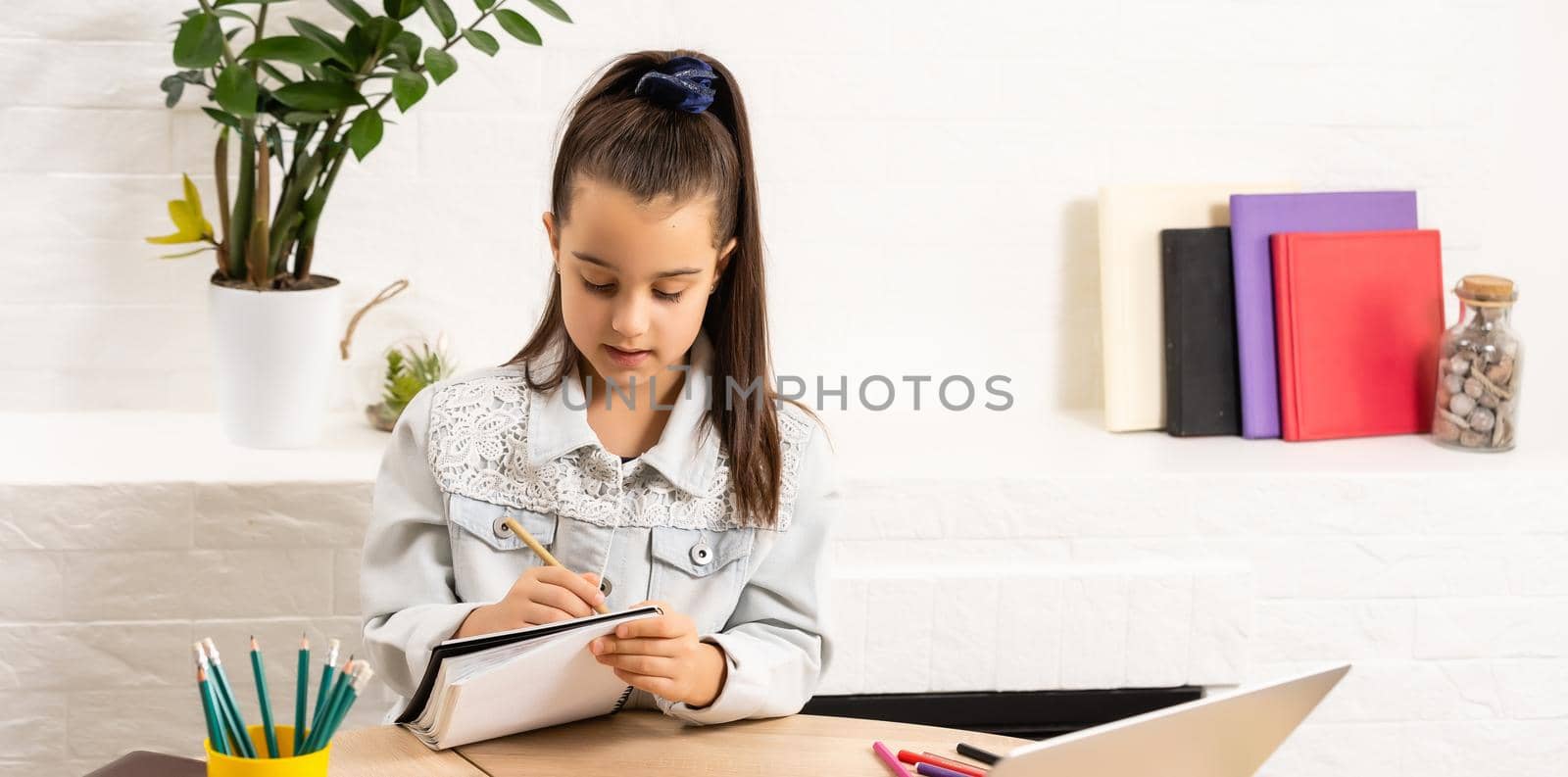 children, education and distant learning concept, little student girl with laptop computer at home by Andelov13