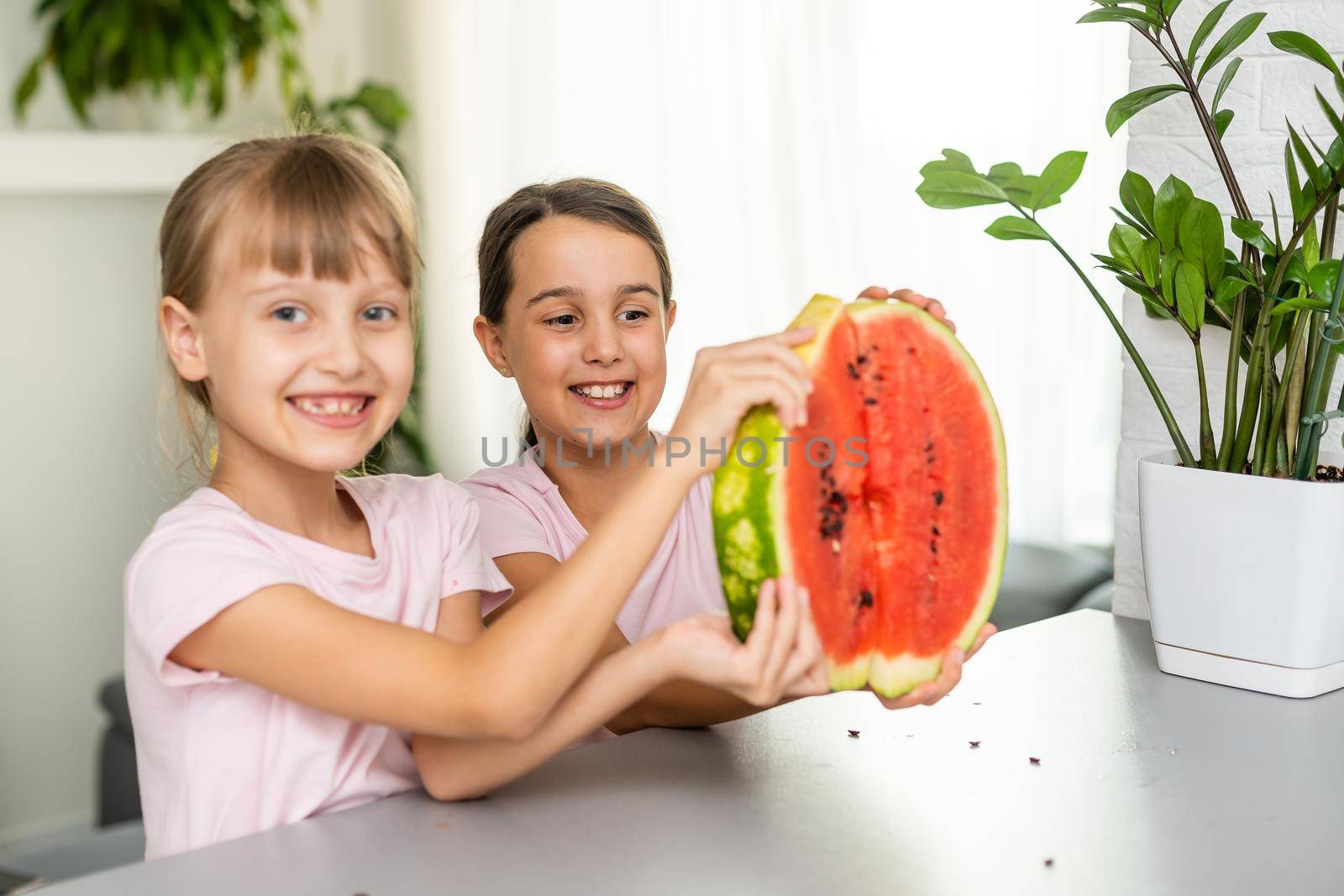 Two girls eating Watermelon isolated at home.