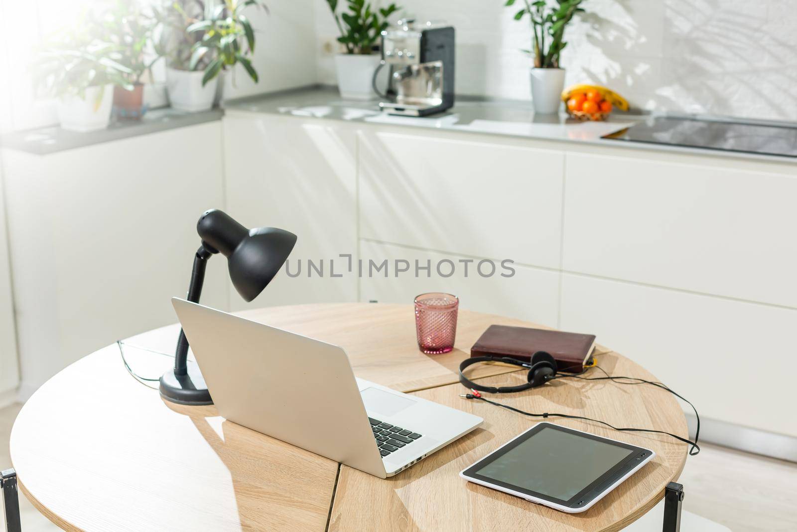 Working from home - a laptop and an organizer on a kitchen table with kitchen in the background.