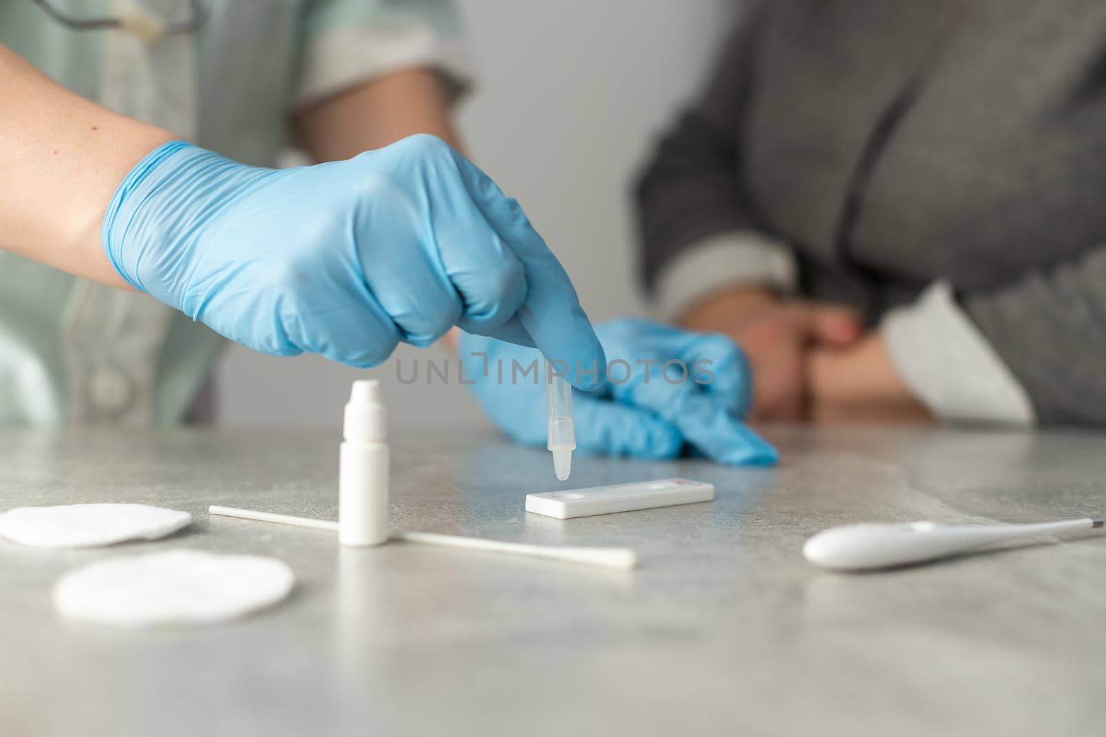 Close up female doctor's hands in white coat and medical gloves holding test tube for testing in hematology laboratory at hospital, medical and science concept.