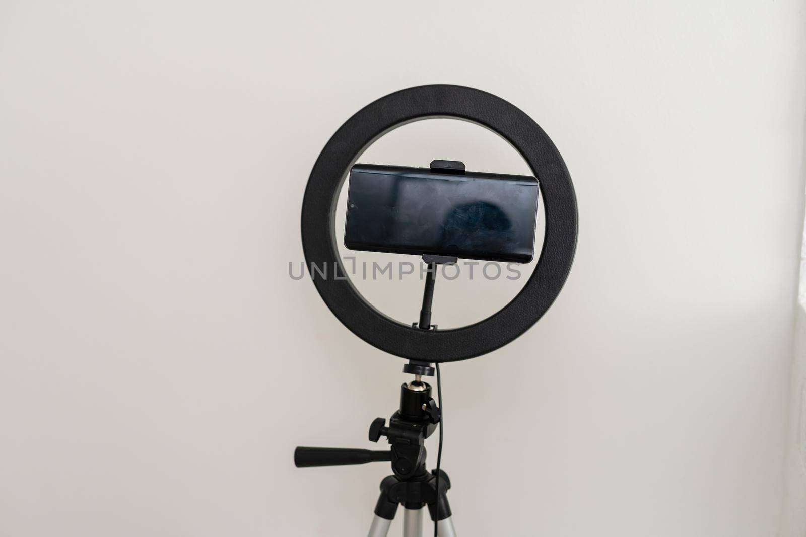 Modern circular neon led lamp for make-up artist or photographers on gray concrete background.