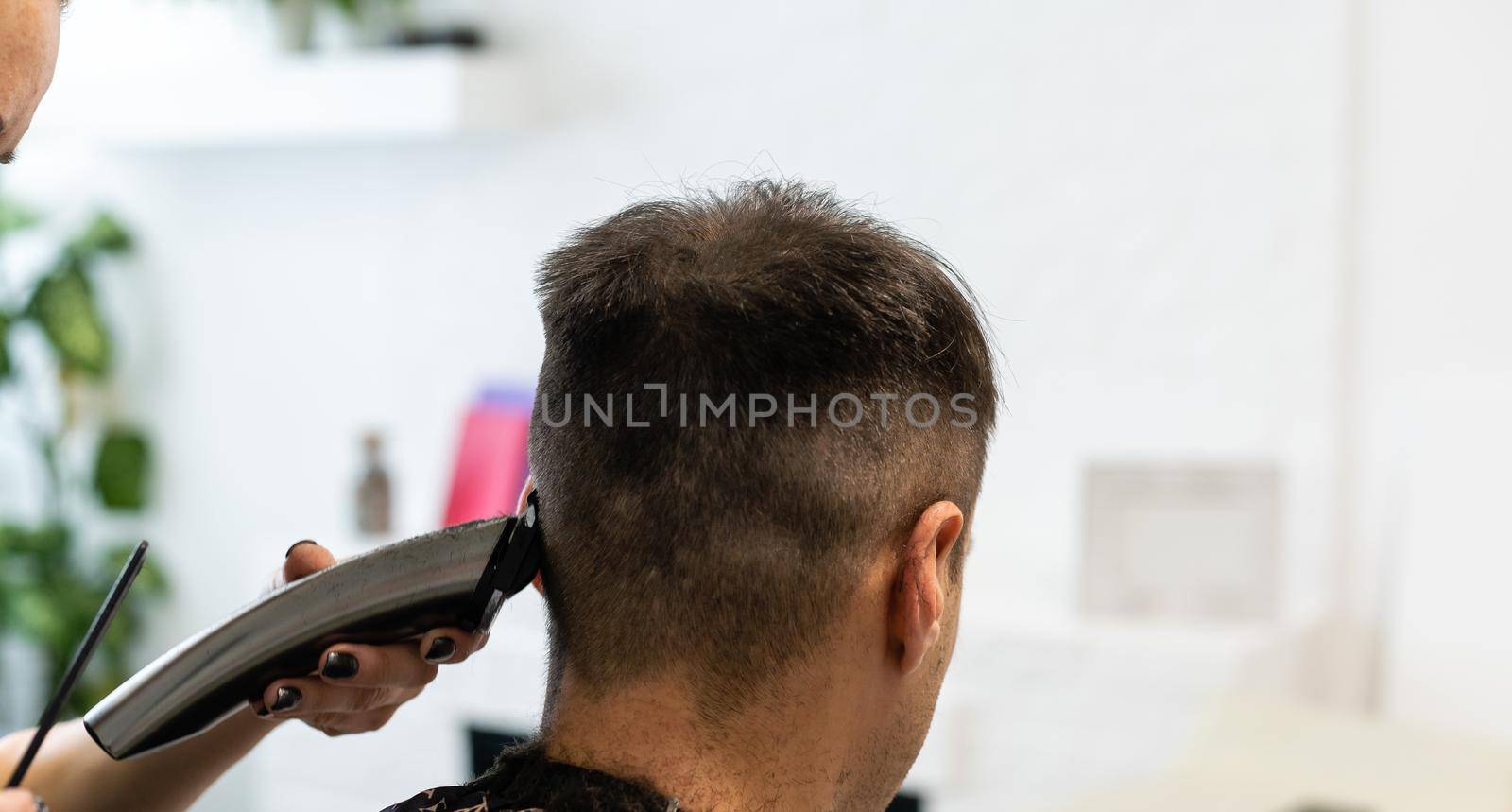 Barber cutting hair with clipper, hairdressing